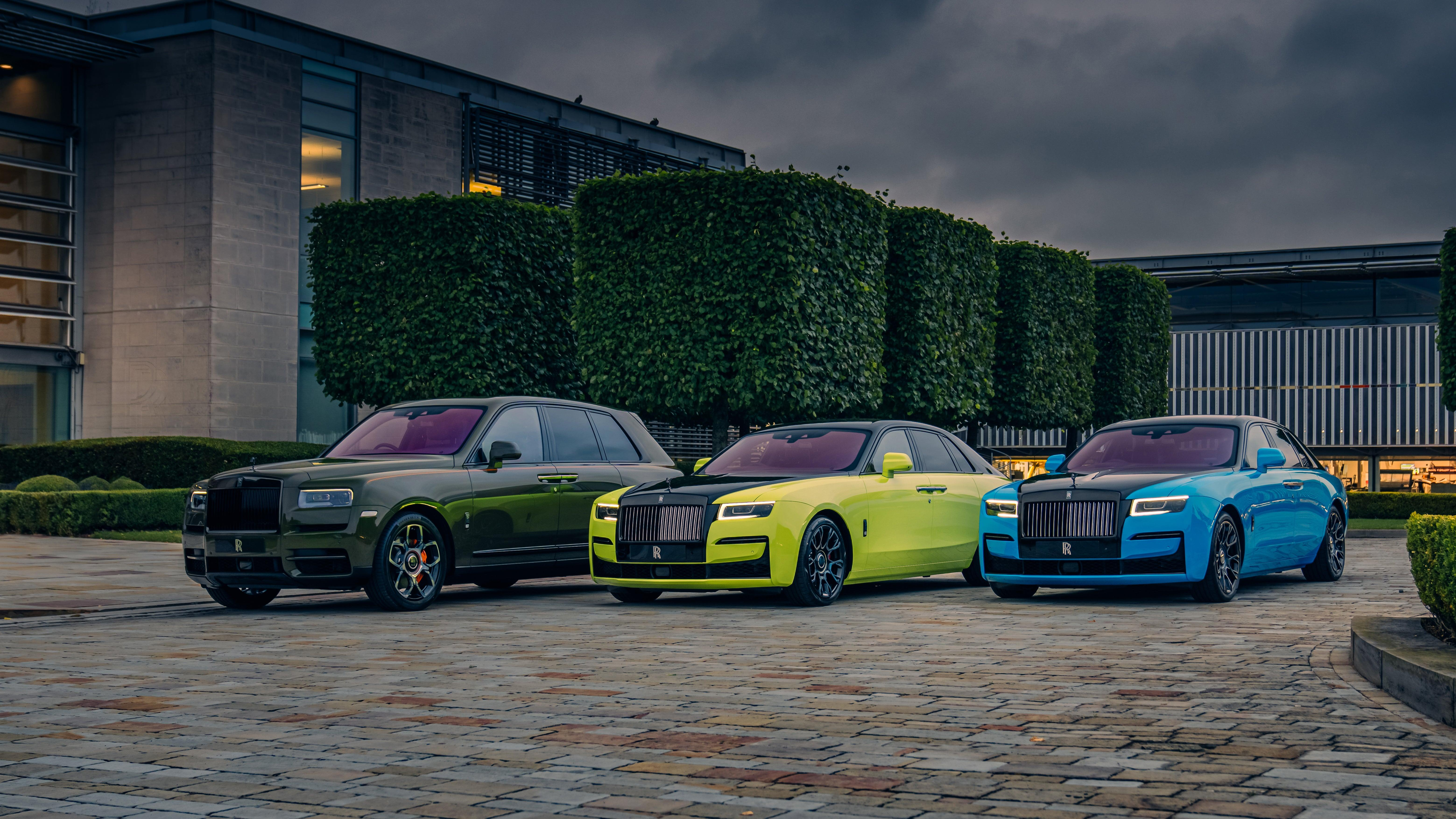 A Rolls-Royce Cullinan and two Rolls-Royce Ghosts parked on cobblestones