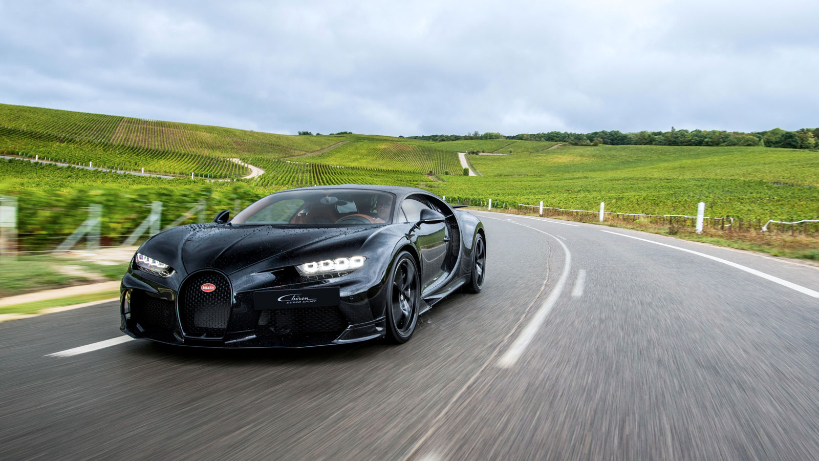 A photo of a black Bugatti Chiron Pur Sport driving on the road in France. 