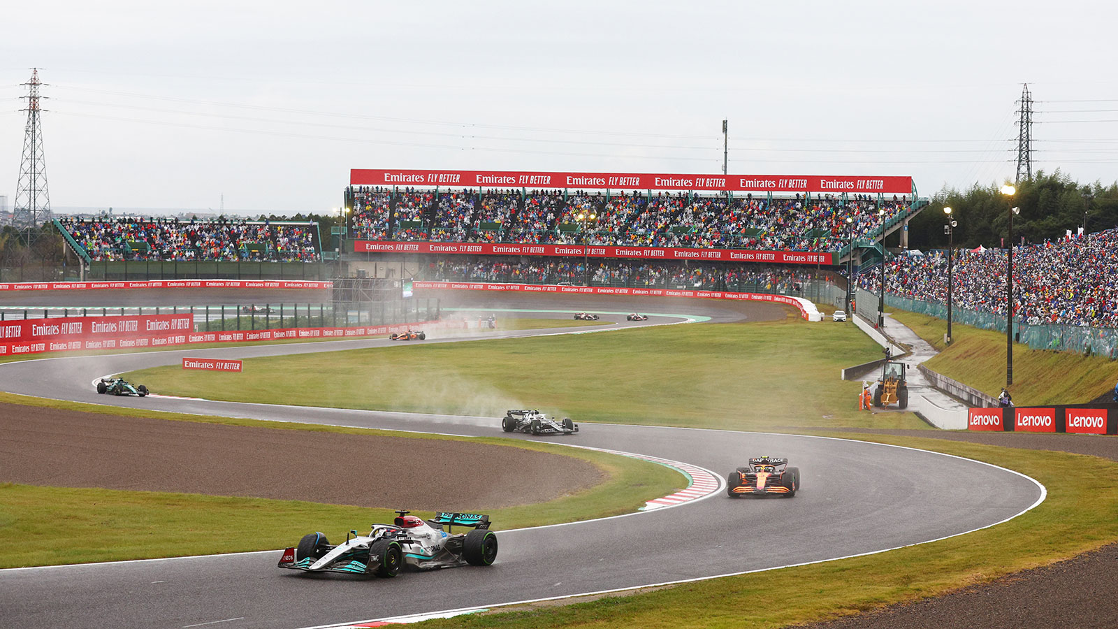 A photo of cars racing in Suzuka, Japan. 