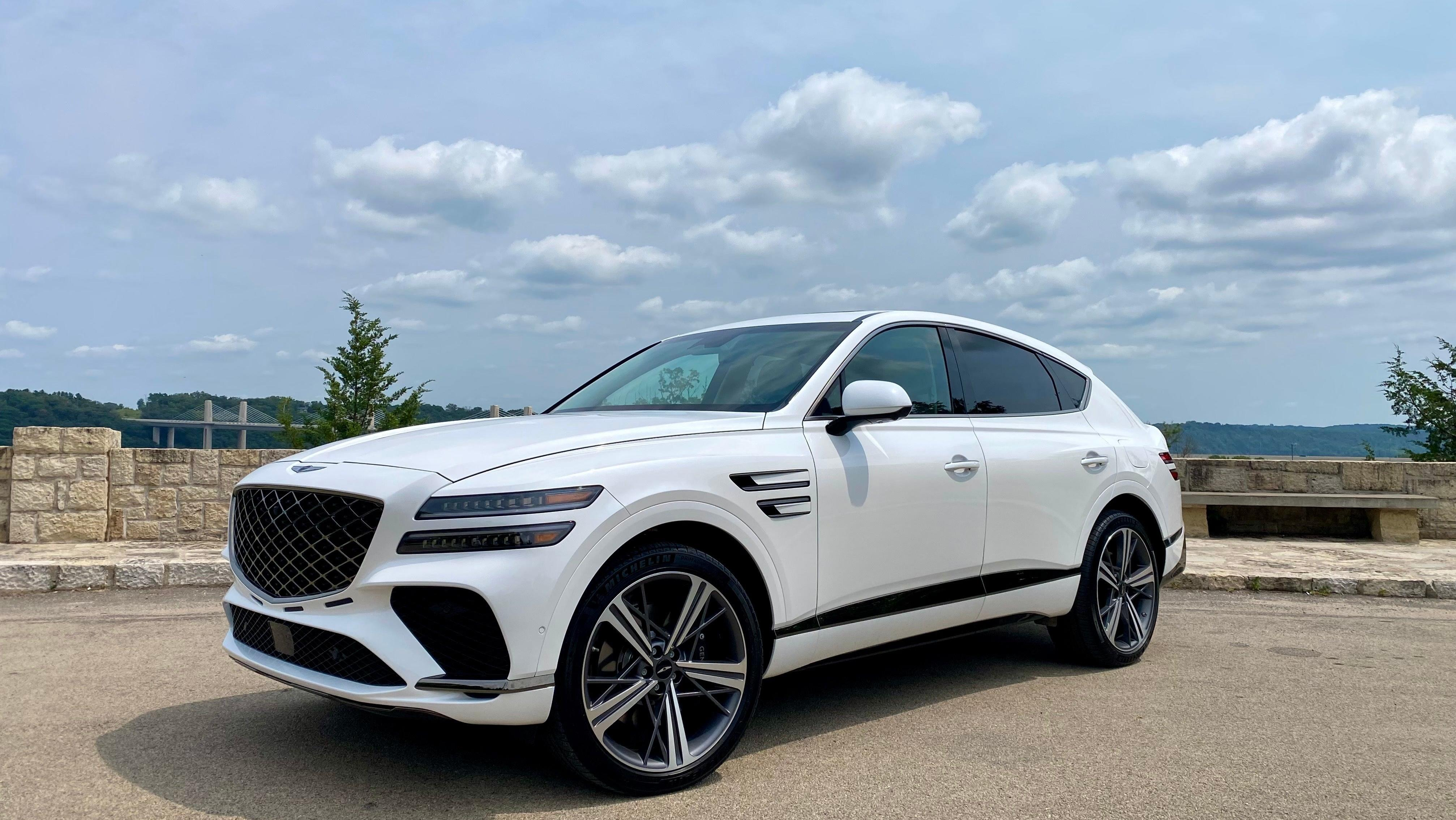 A front 3/4 shot of the white GV80 Coupe parked in front of a vista