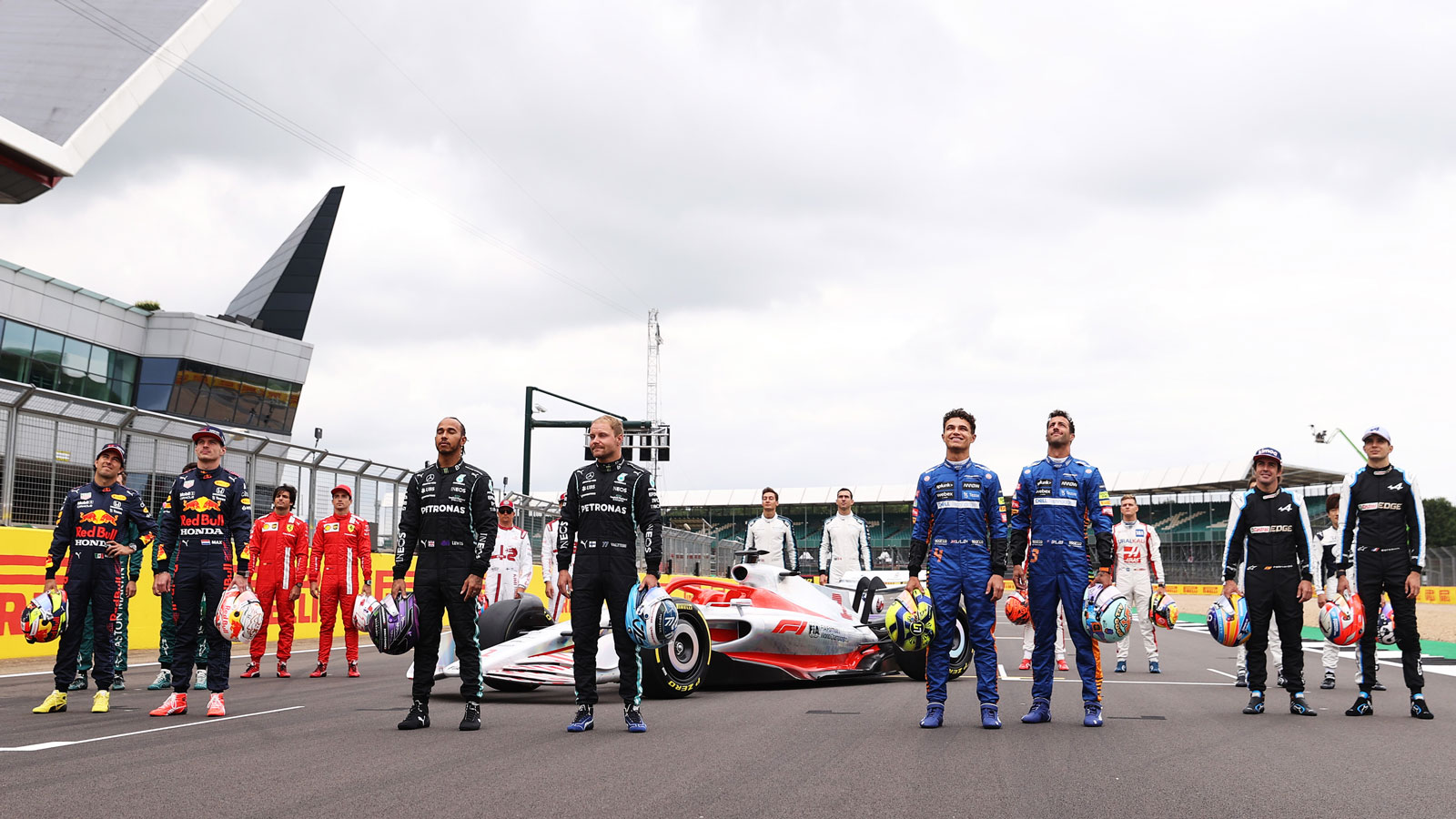 Formula 1 drivers gather around a model of the new F1 car. 