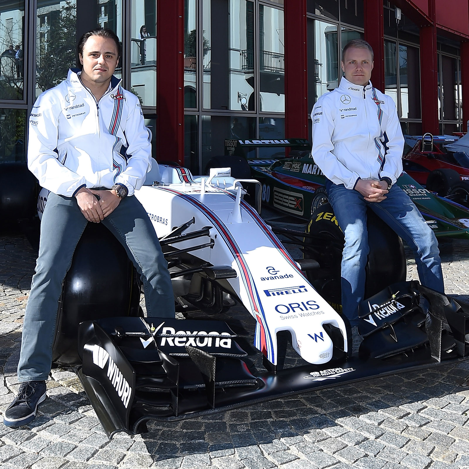 A photo of Valtteri Bottas and Felipe Massa sitting on a Williams F1 car. 