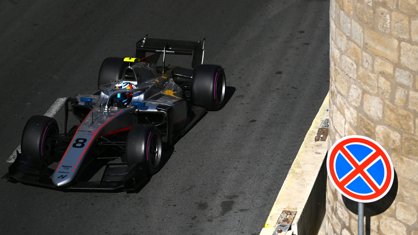 A photo of Juri Vips racing his silver Hitech GP car in Baku. 