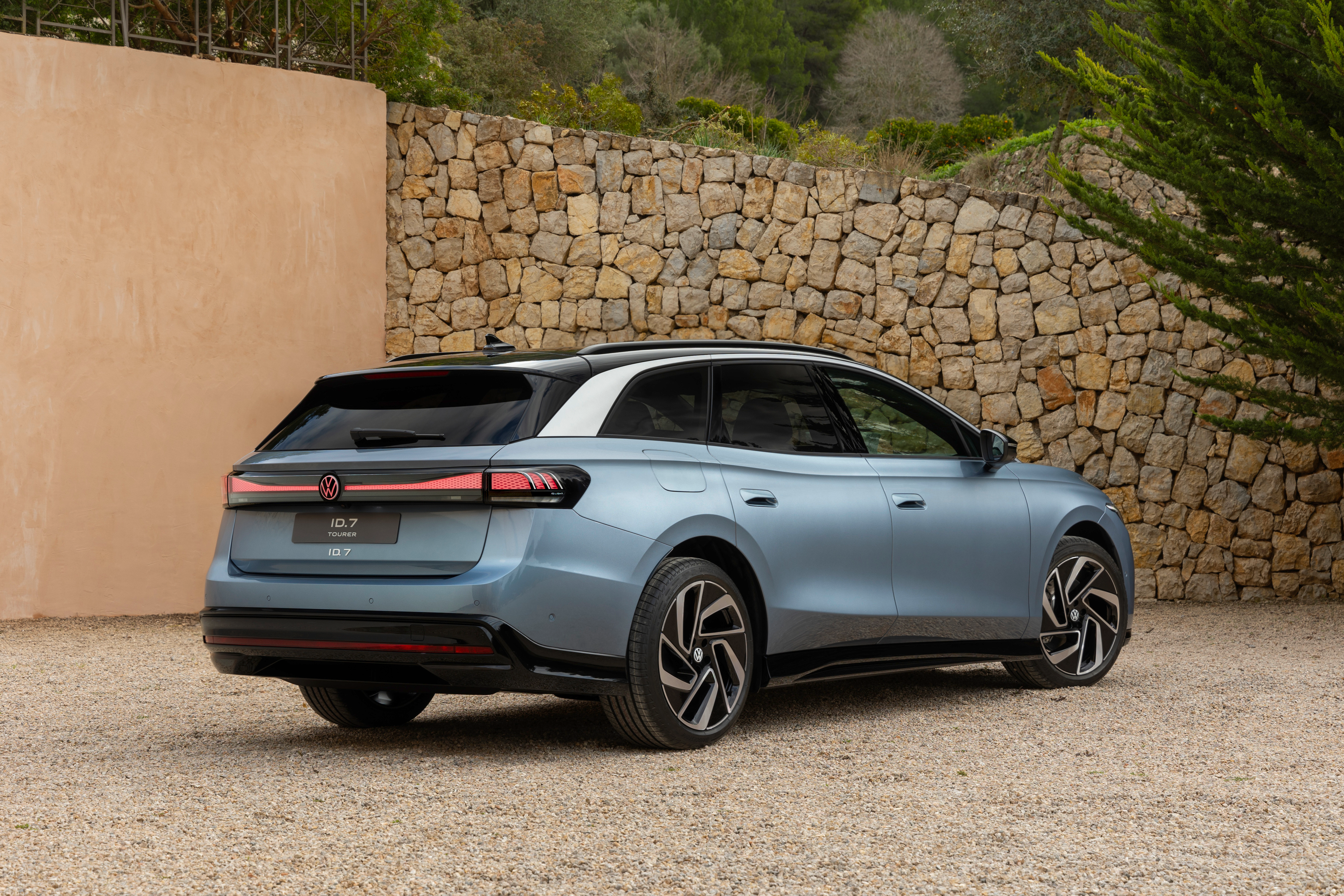 Rear 3/4 view of a light blue Volkswagen ID 7 Tourer