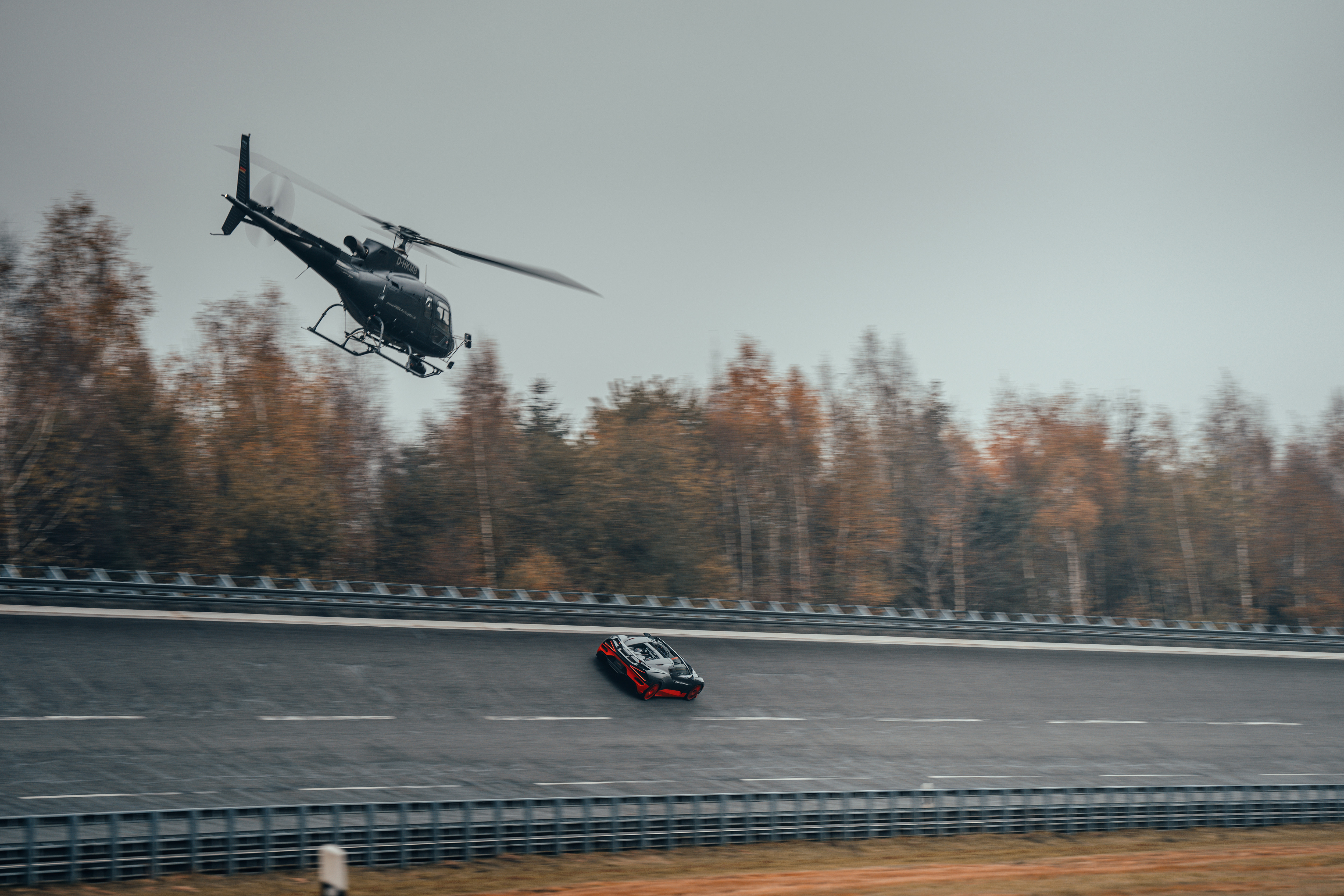 Black and orange Bugatti W16 Mistral World Record Car being chased by a helicopter