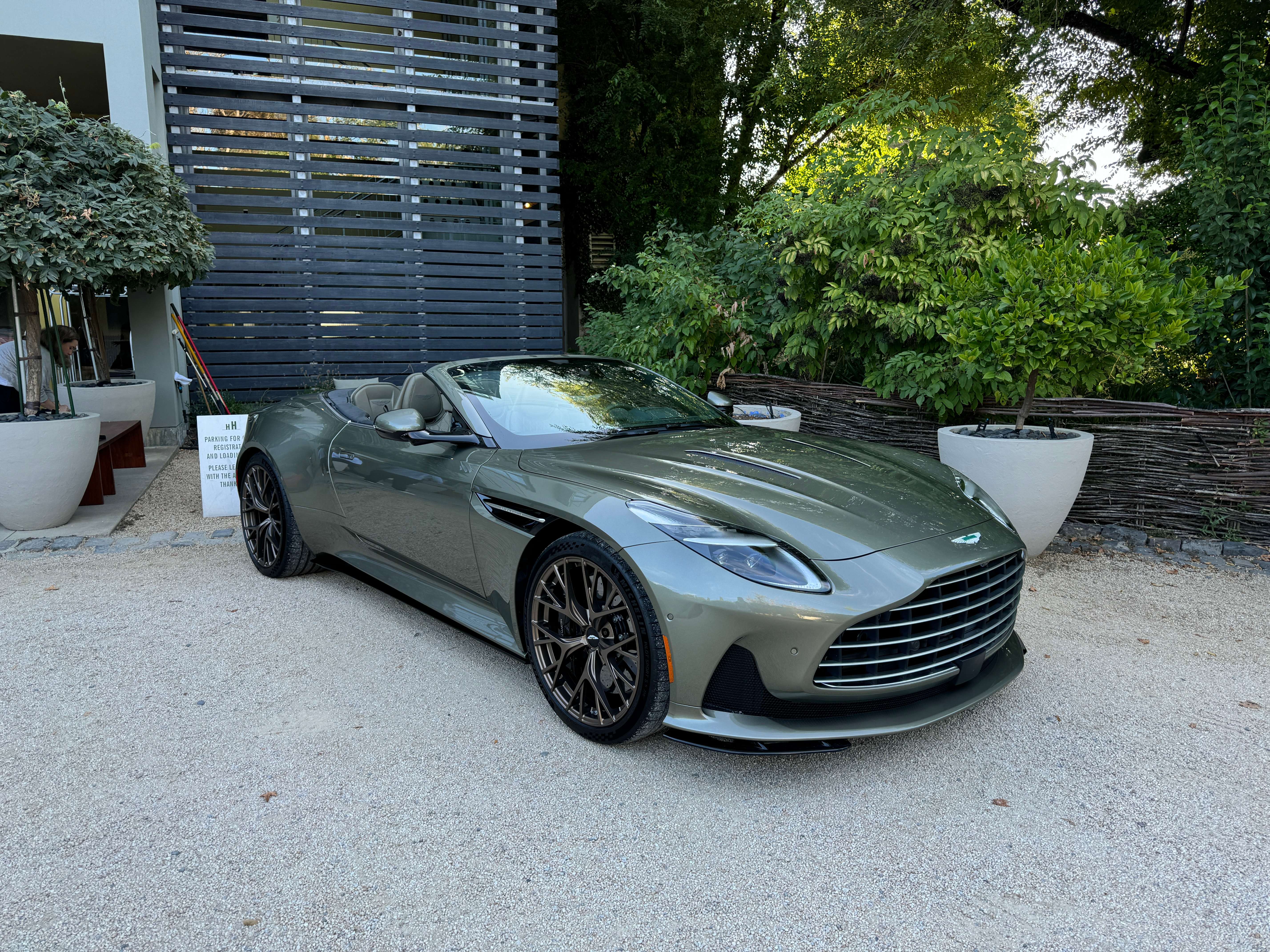 Front 3/4 view of a green Aston Martin DB12 Volante