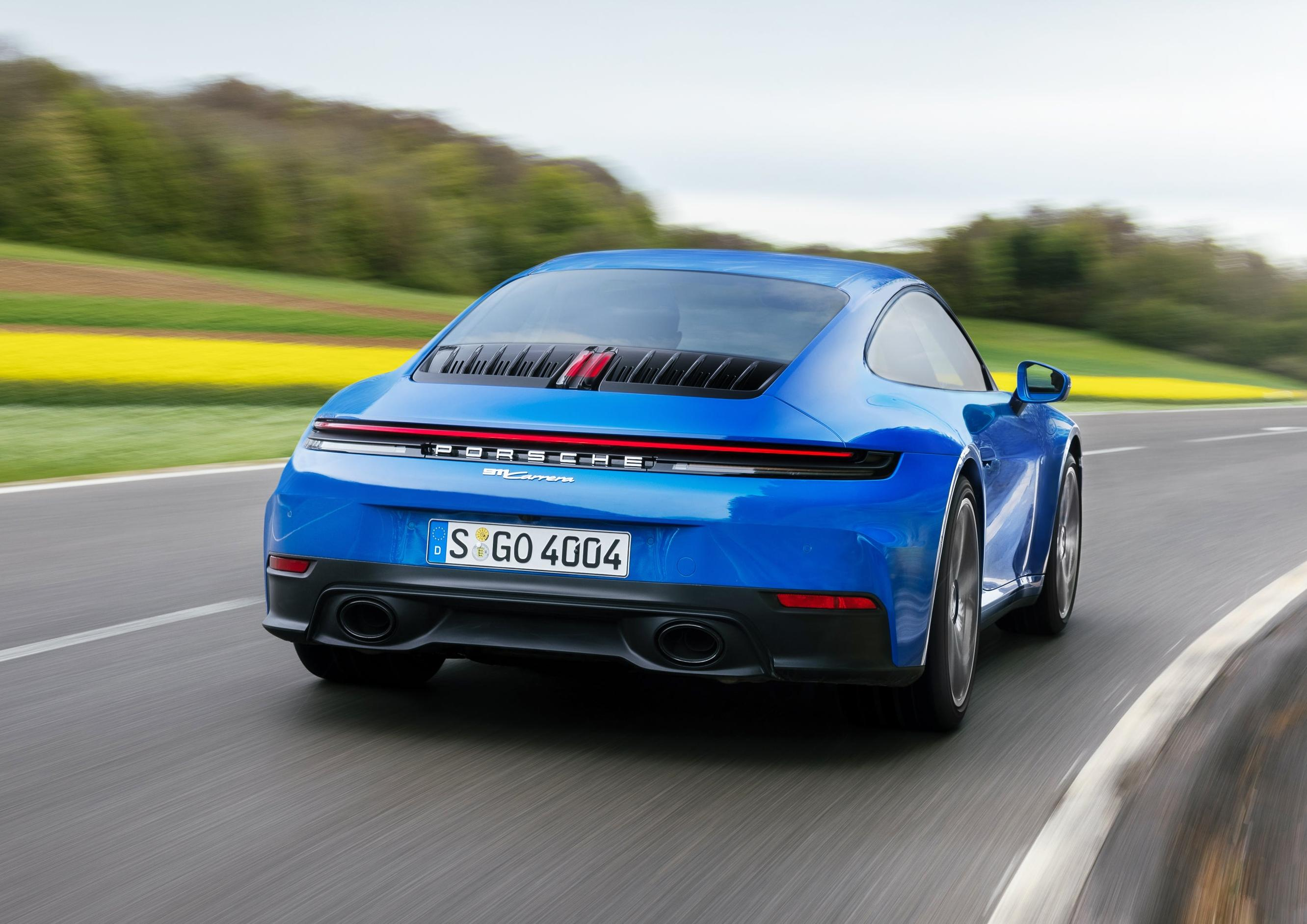 Rear 3/4 view of a blue 2025 Porsche 911 Carrera