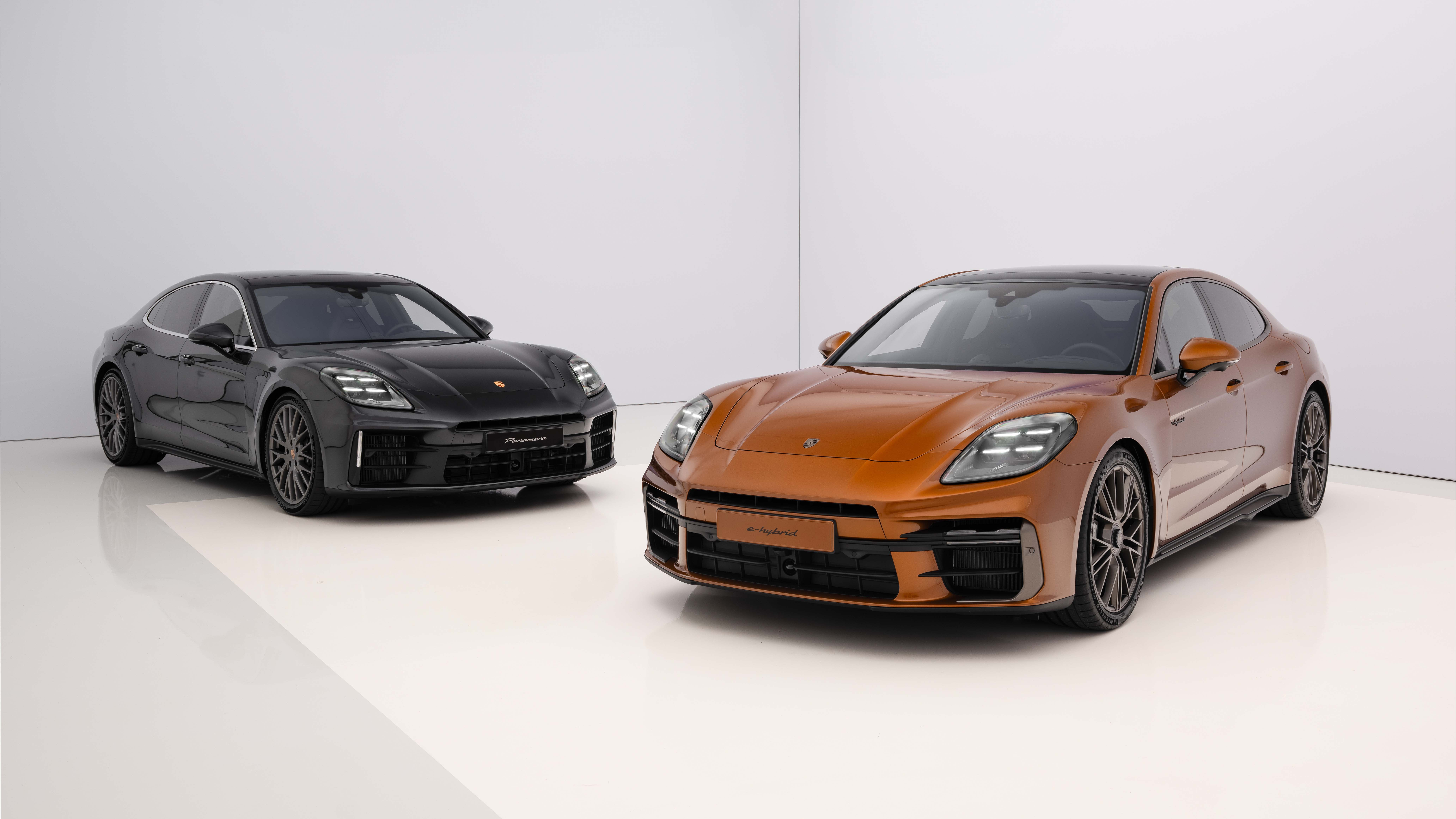 Two 2024 Porsche Panameras at a 3/4 angle, one painted black and the other orange