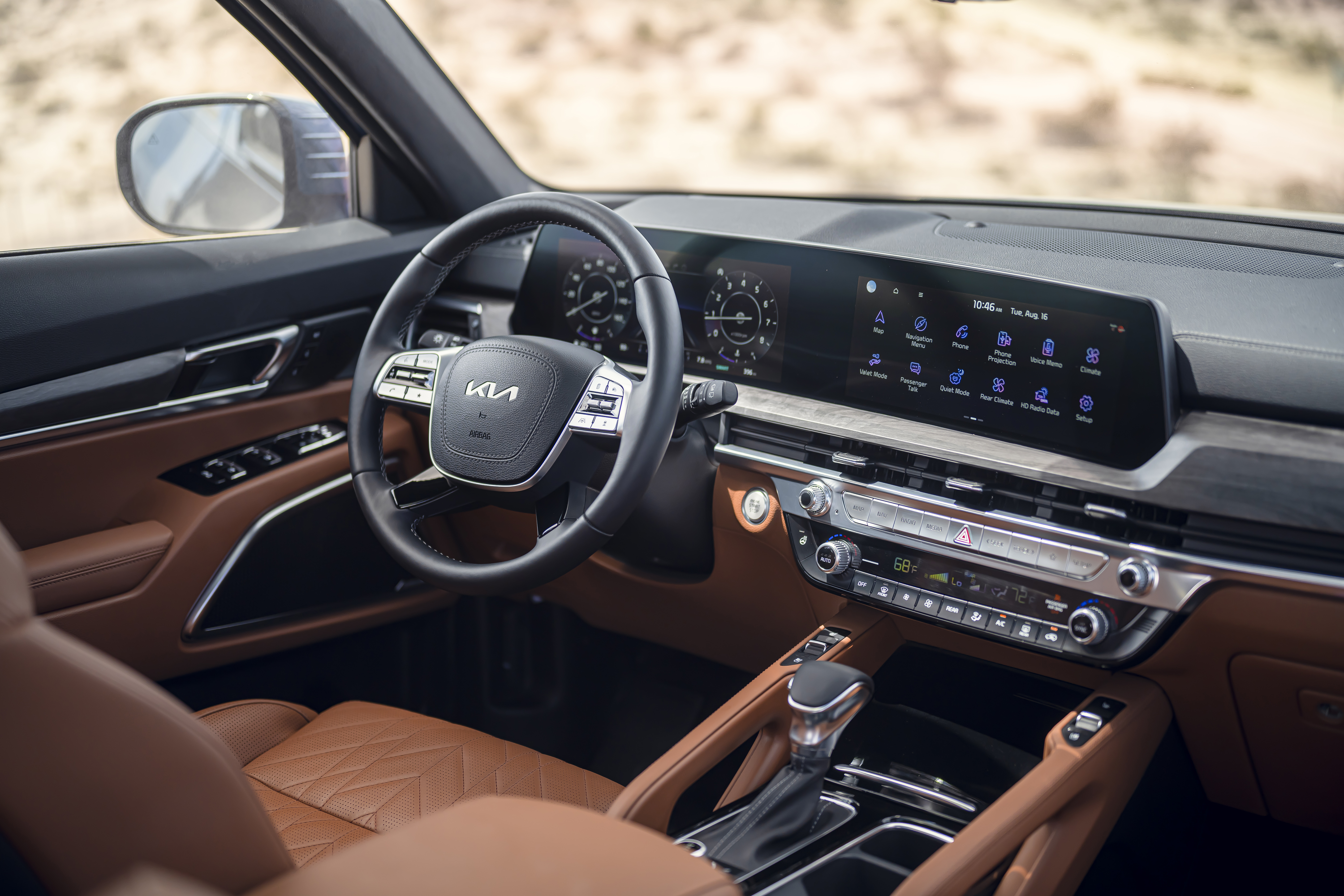 The interior of the 2023 Kia Telluride SX X-Pro, shown with caramel brown leather upholstery and a detailed view of the steering wheel and center console.