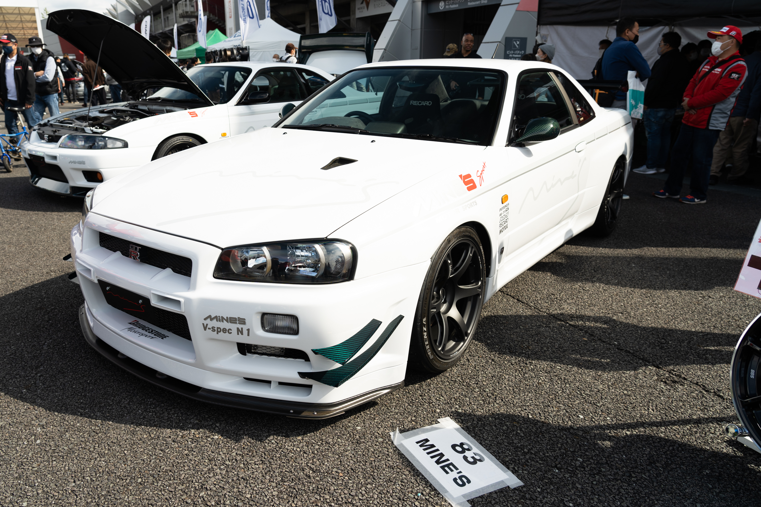 a white nissan gt-r with turquoise accents parked at r's meeting