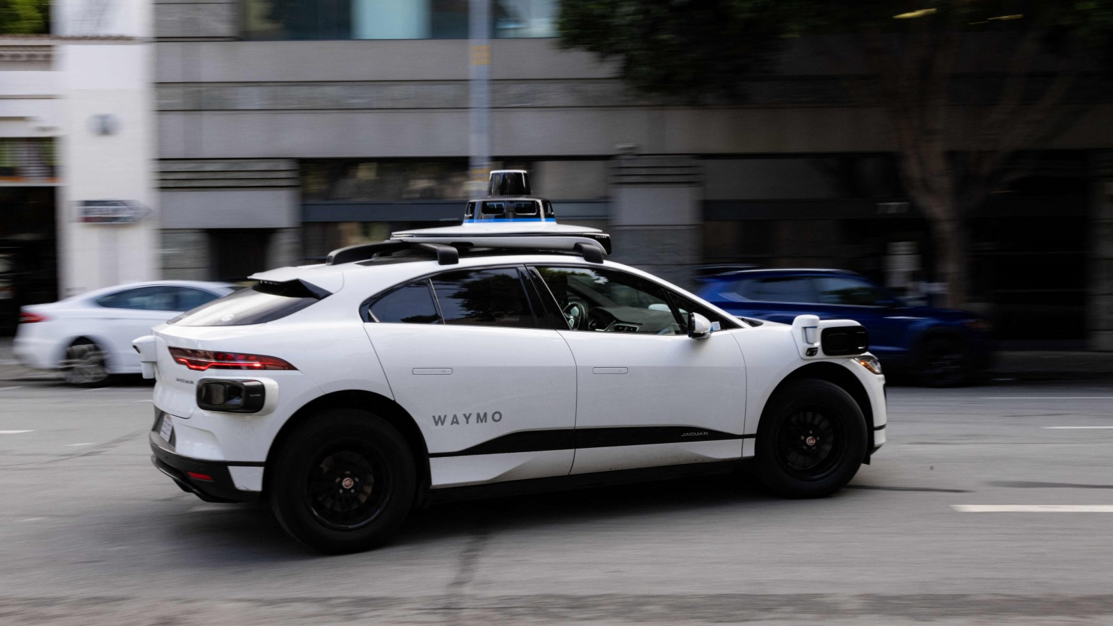 A photo of a Waymo self-driving taxi on the street. 