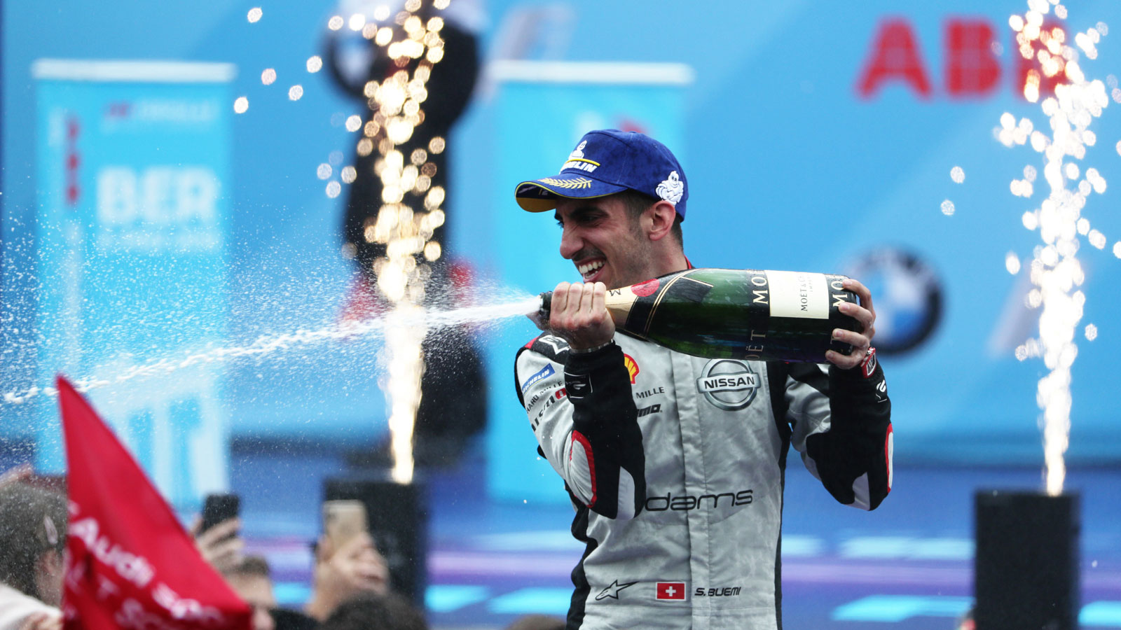 A photo of Sébastien Buemi spraying Champagne on the Formula E podium. 