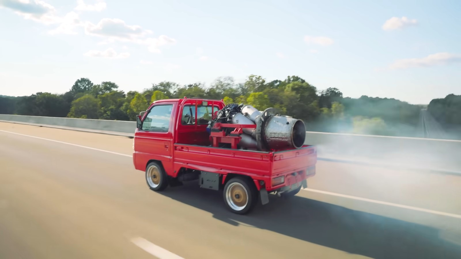 A screenshot showing smoke coming from a jet engine on the back of a truck. 