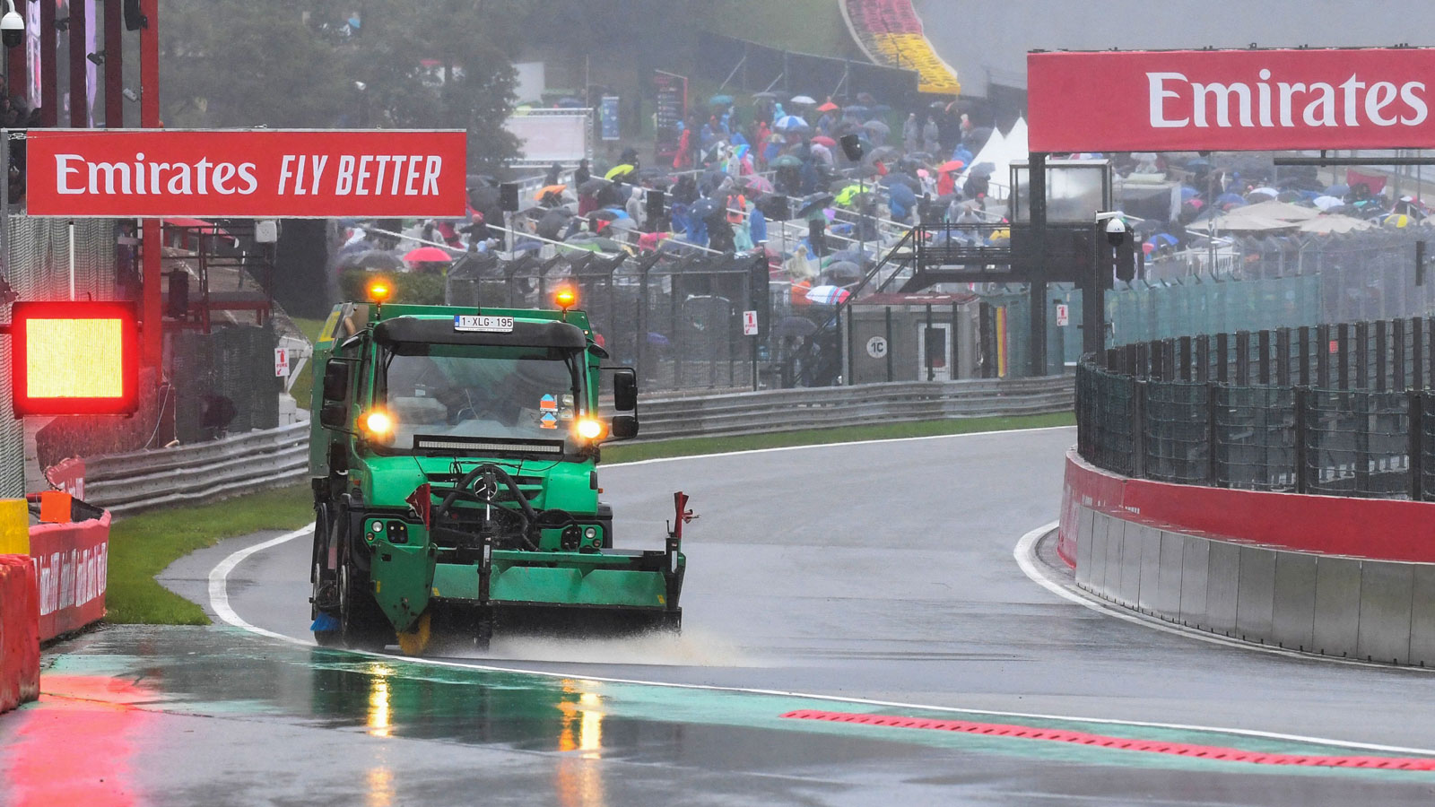 A sweeper truck tries to clear rain from the race track in Belgium 