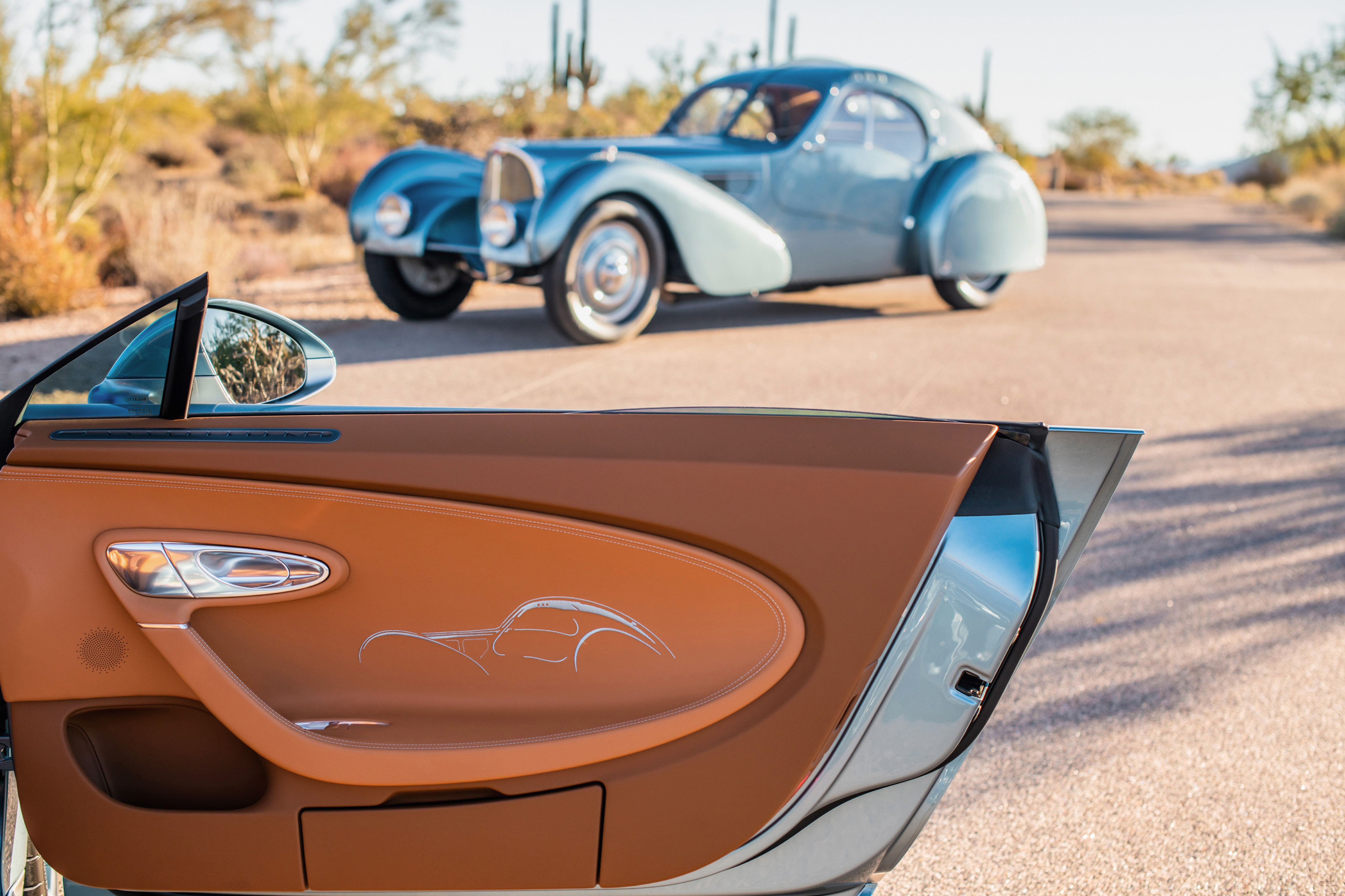 Detail shot of a Bugatti Chiron Super Sport's door panel with a Type 57 SC Atlantic in the background