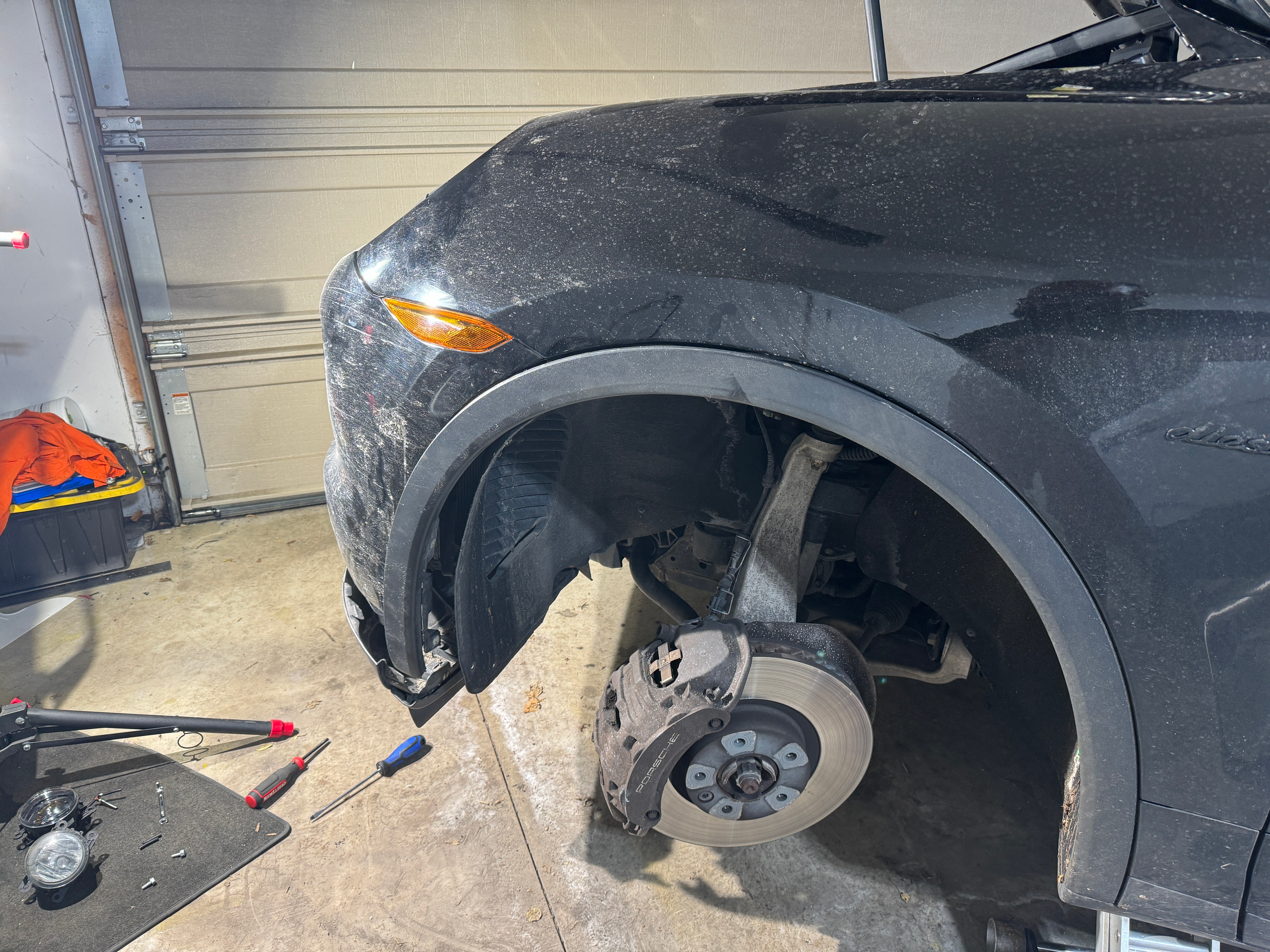 Front wheel well of a 2013 Porsche Cayenne Diesel with the wheel removed to install fog lights