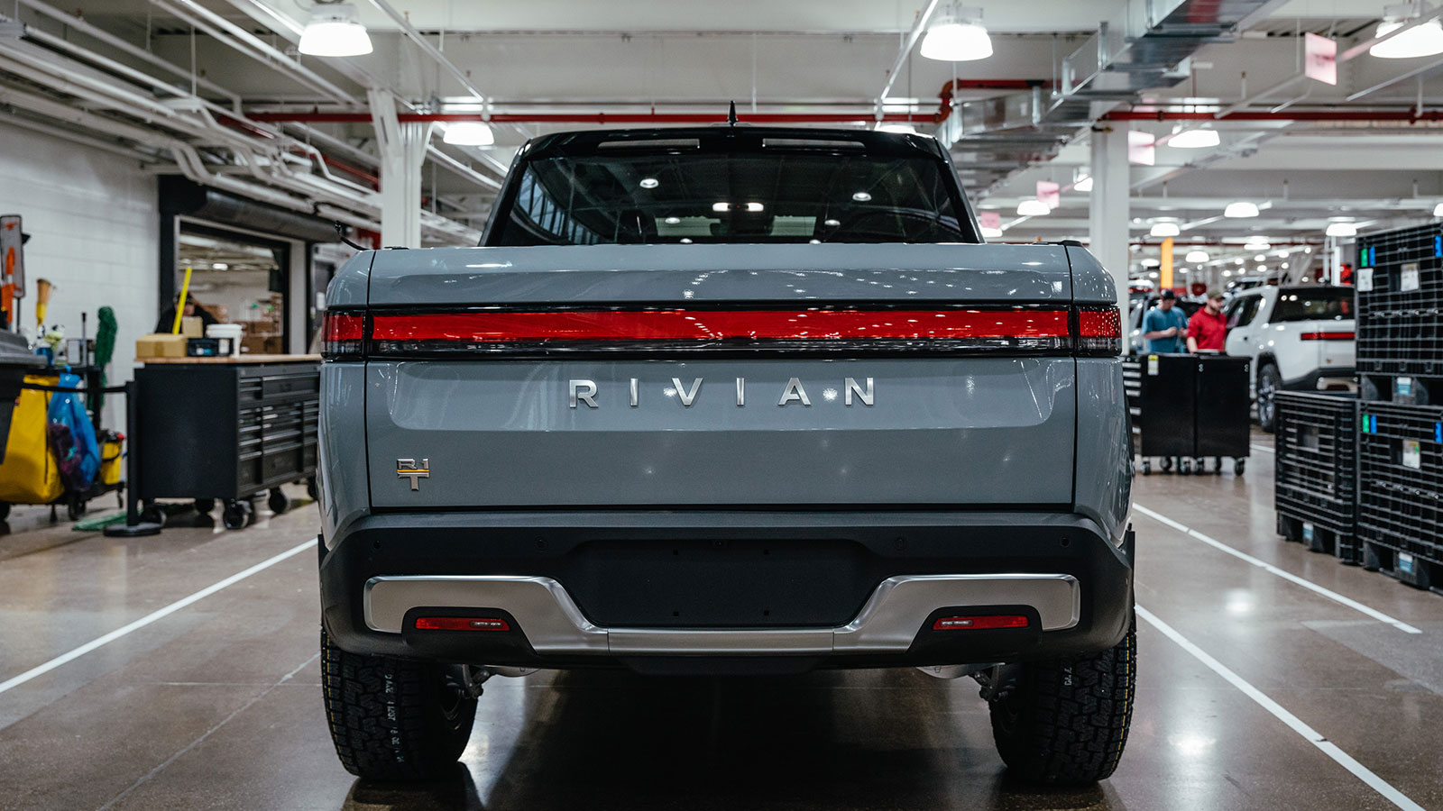 A photo of the rear of a Rivian electric pickup truck at the factory. 