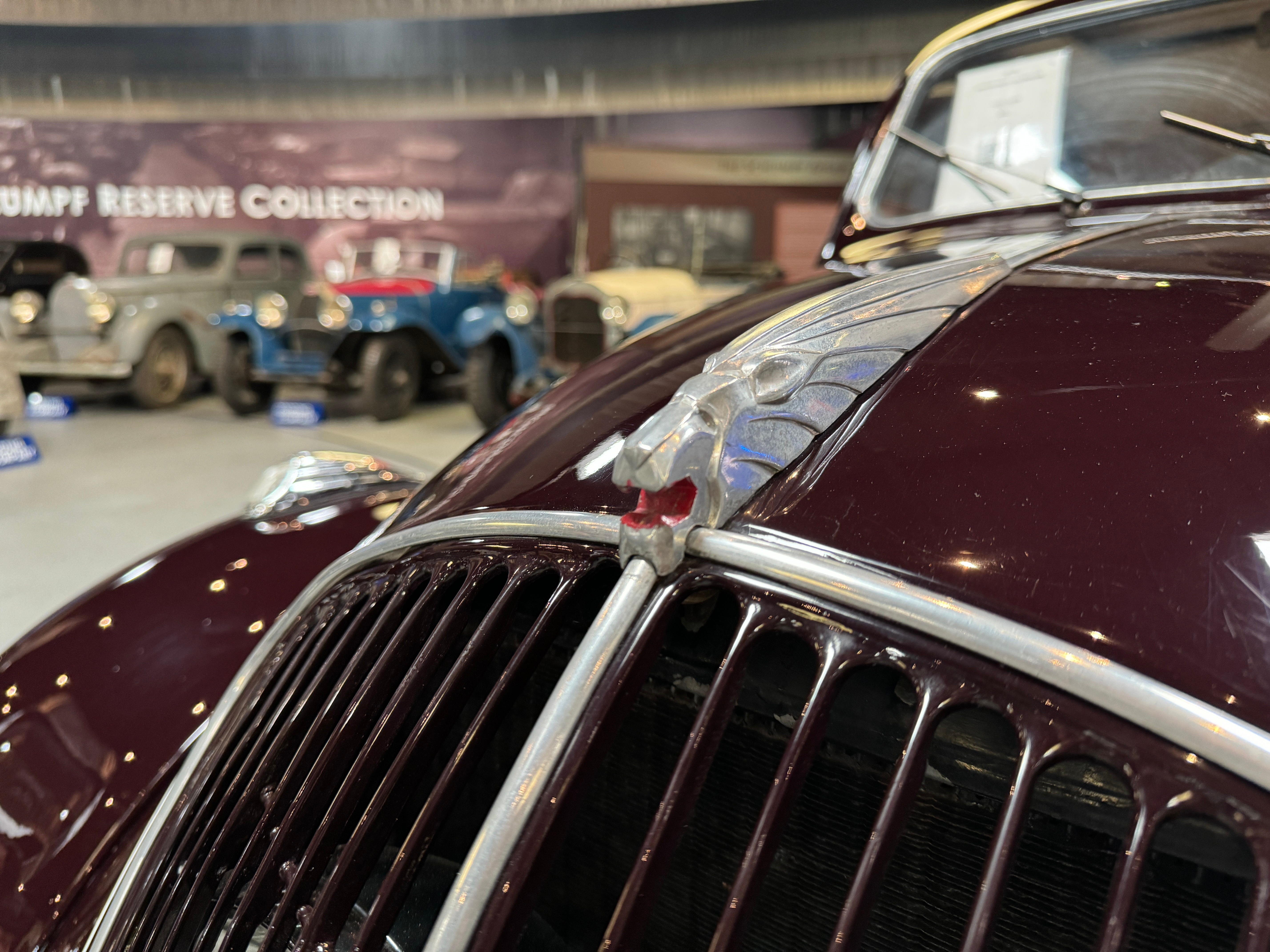 Hood ornament of a red 1939 Peugeot 202 Berline