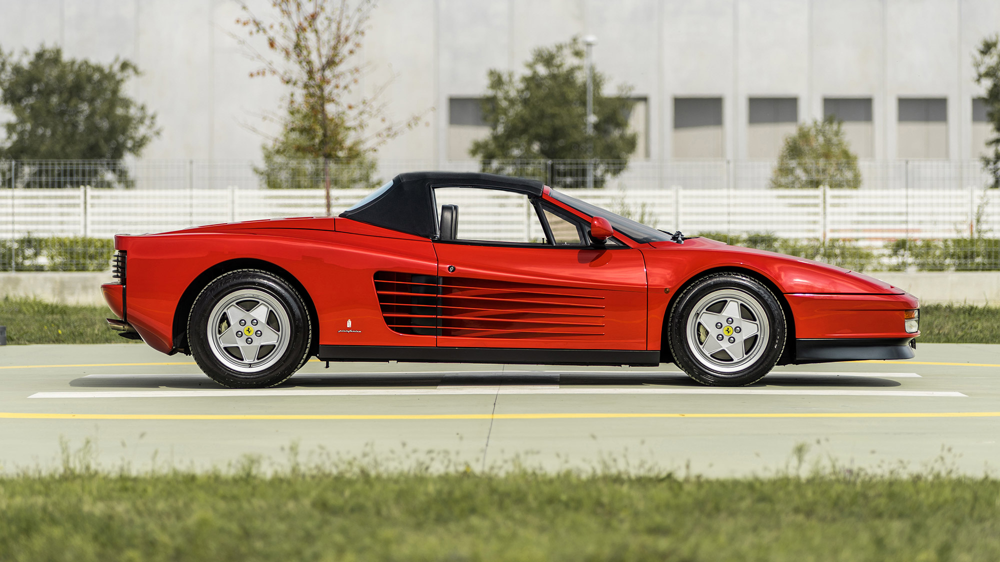 Profile view with closed top of red Ferrari Testarossa Pininfarina Spider 