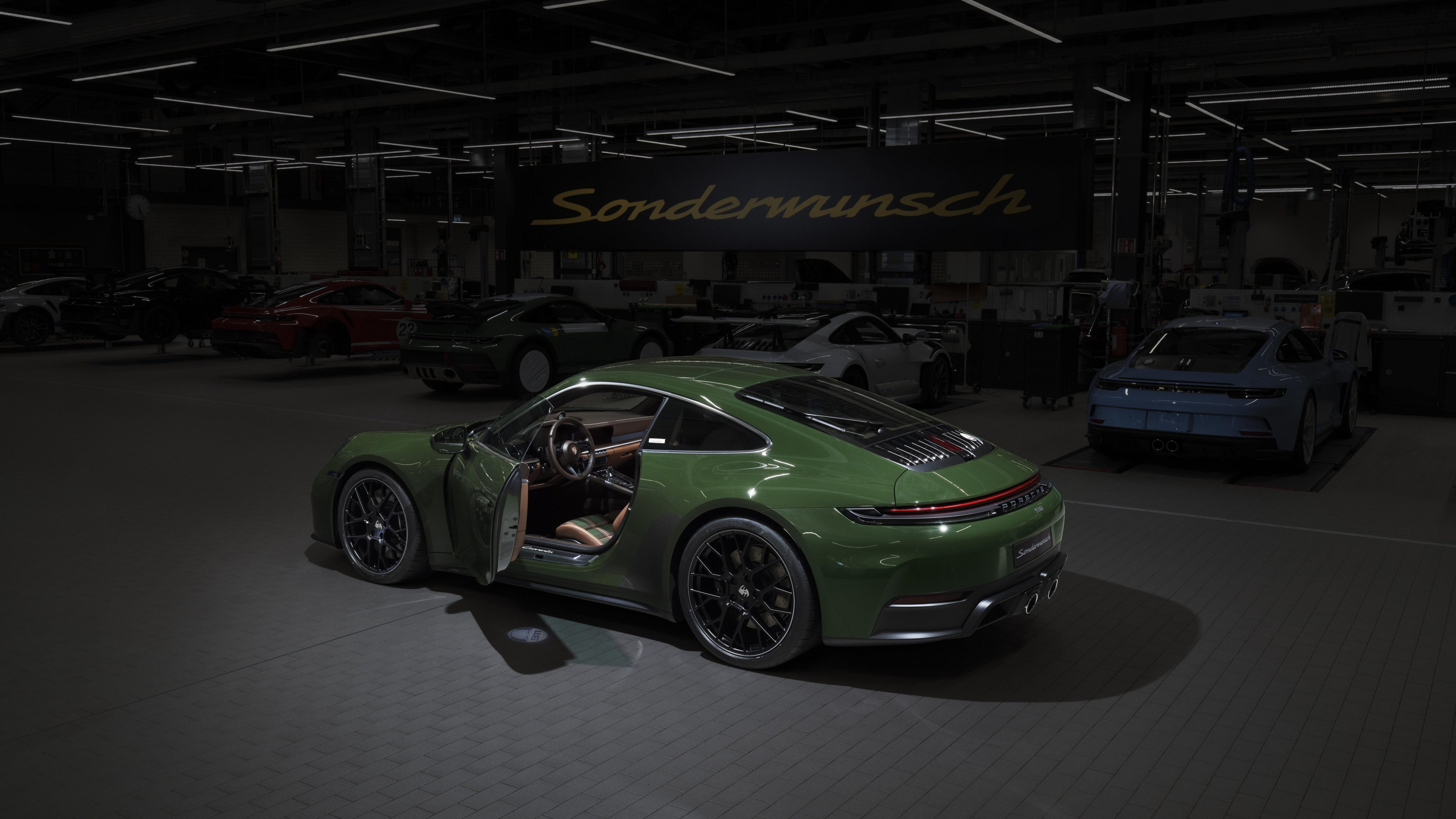 Rear 3/4 view of a green Porsche 911 Cuarenta Edition