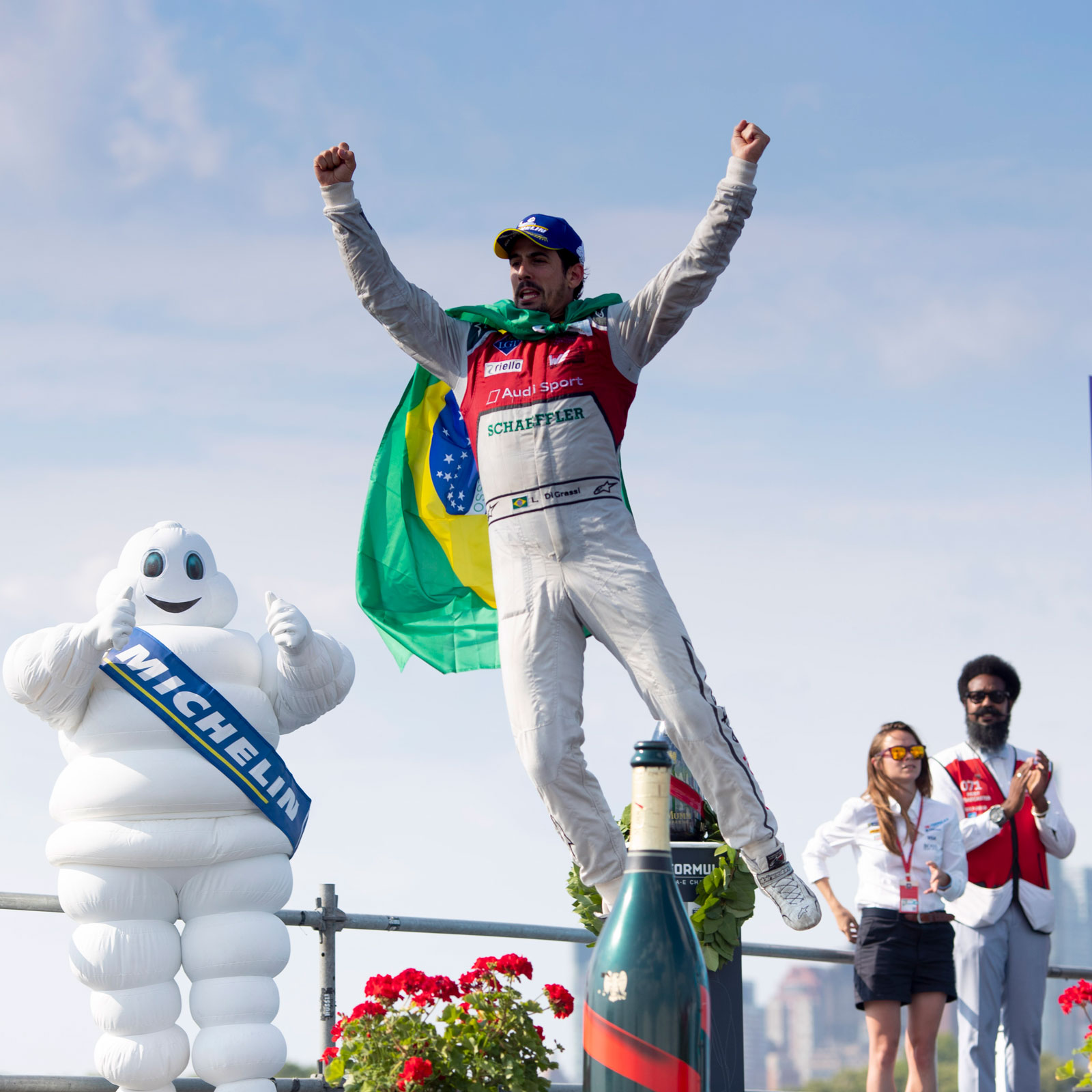 A photo of Lucas Di Grassi jumping off the podium in New York City. 