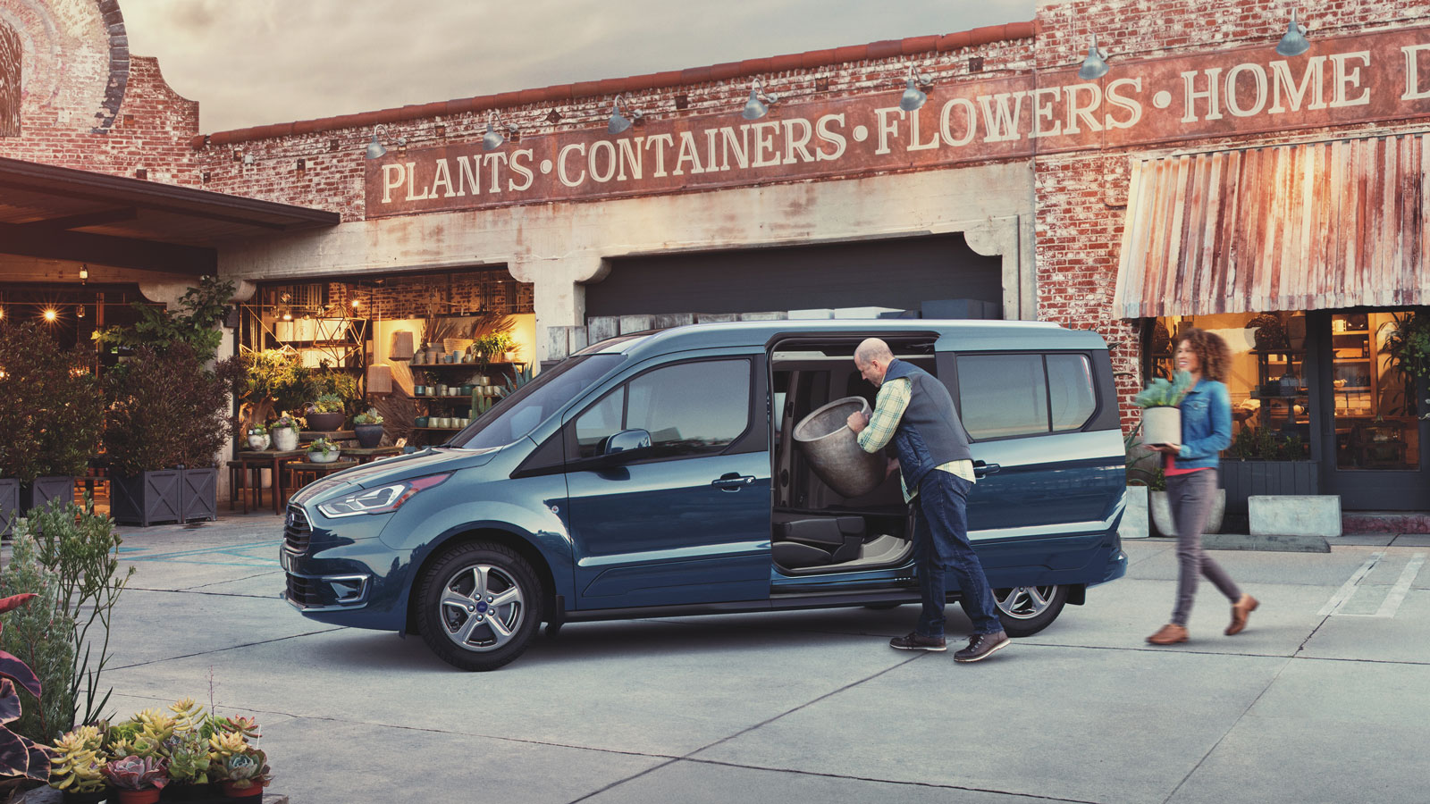 A photo of a blue Ford Transit Connect at a garden center. 