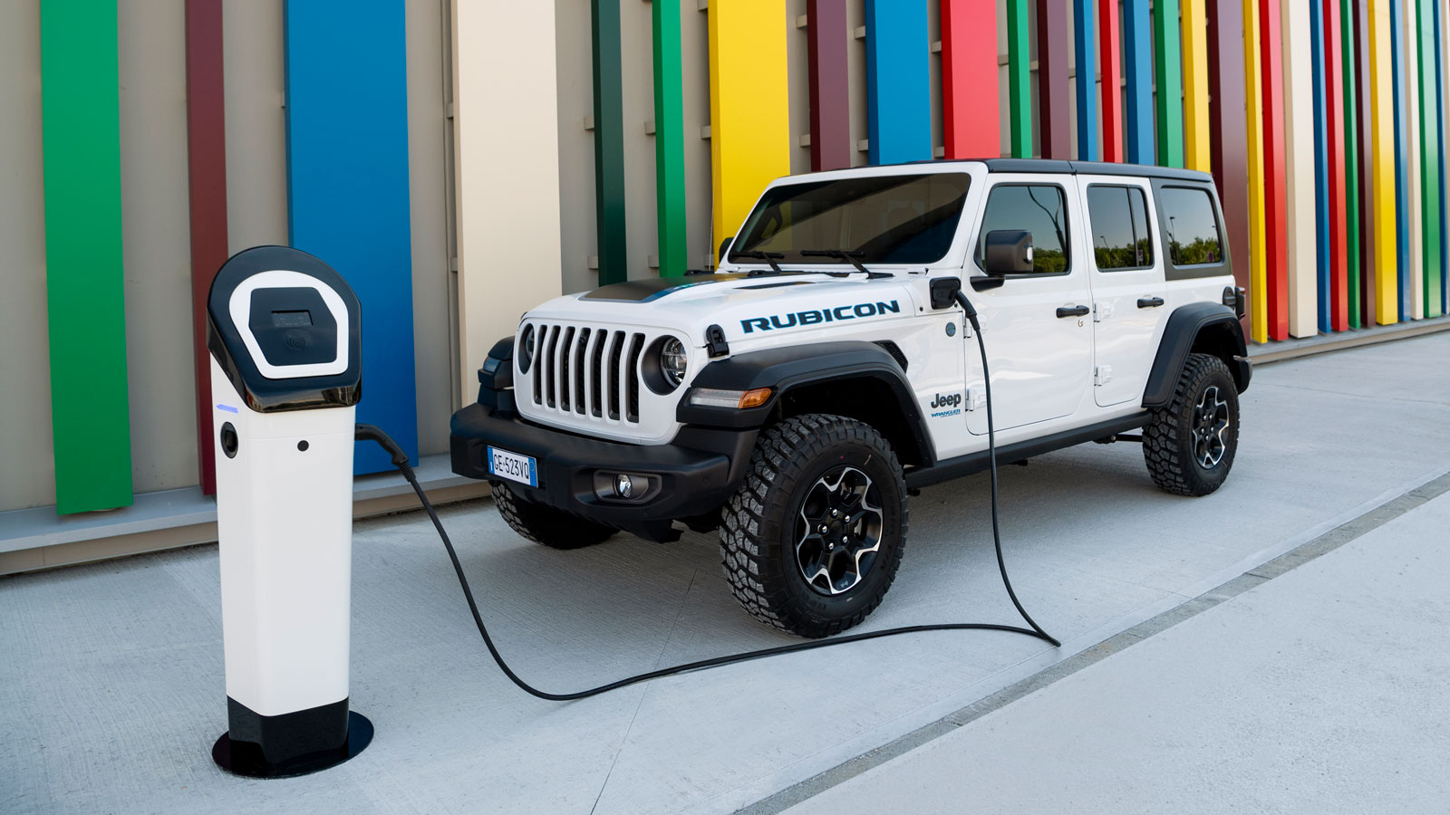 A Jeep Wrangler plugged into a wall charger 