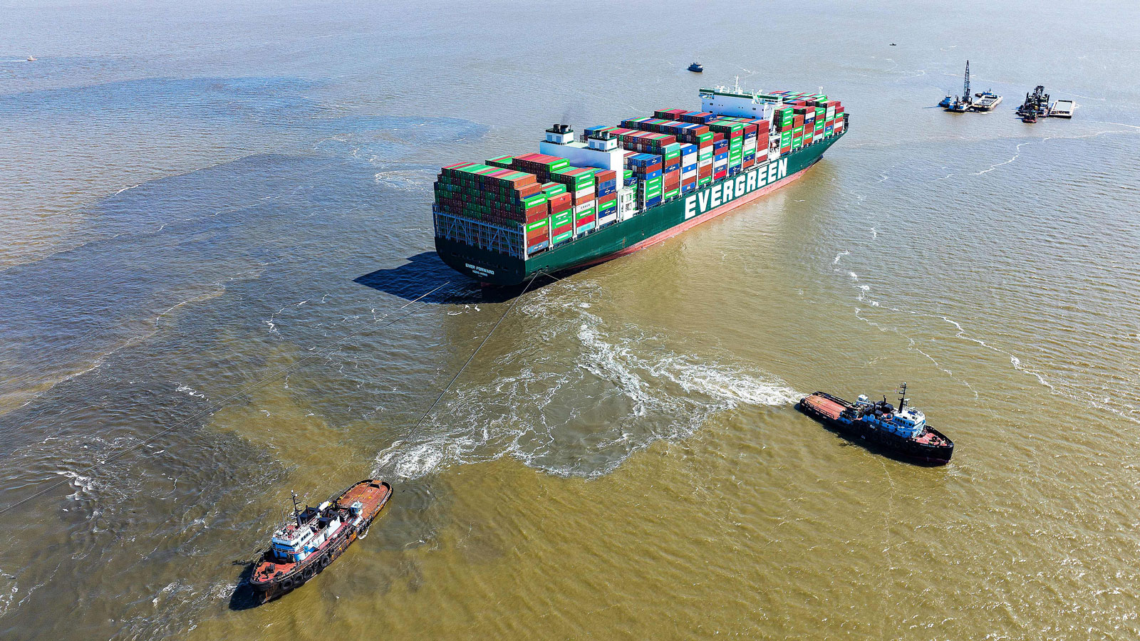 Tug boats pull on the Ever Forward container ship. 