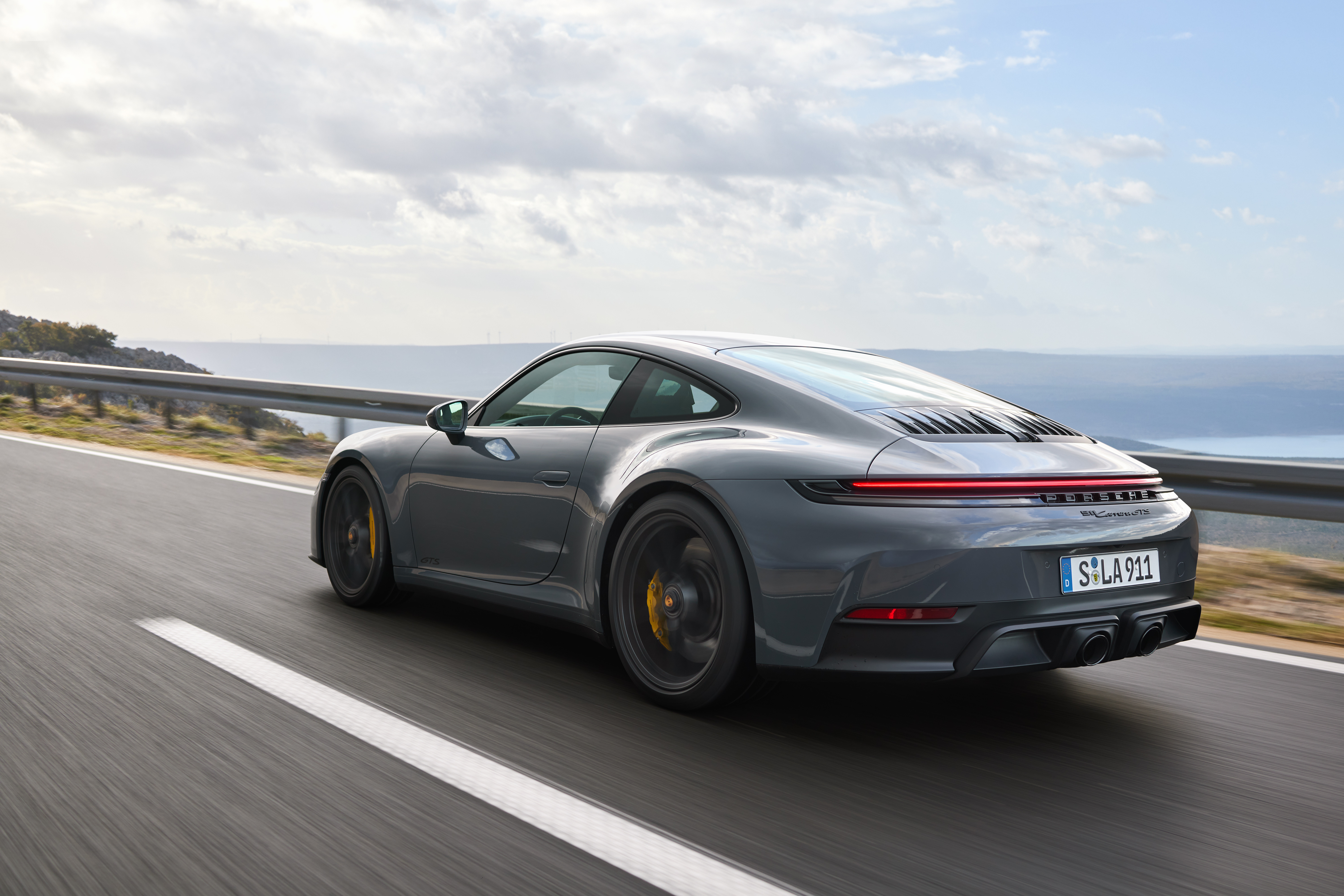 Rear 3/4 view of a grey 2025 Porsche 911 Carrera GTS