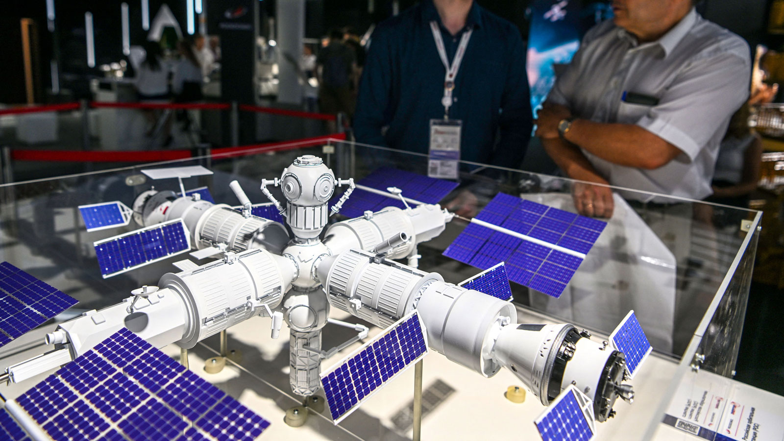 A photo of people looking at a model of a space station in Russia. 