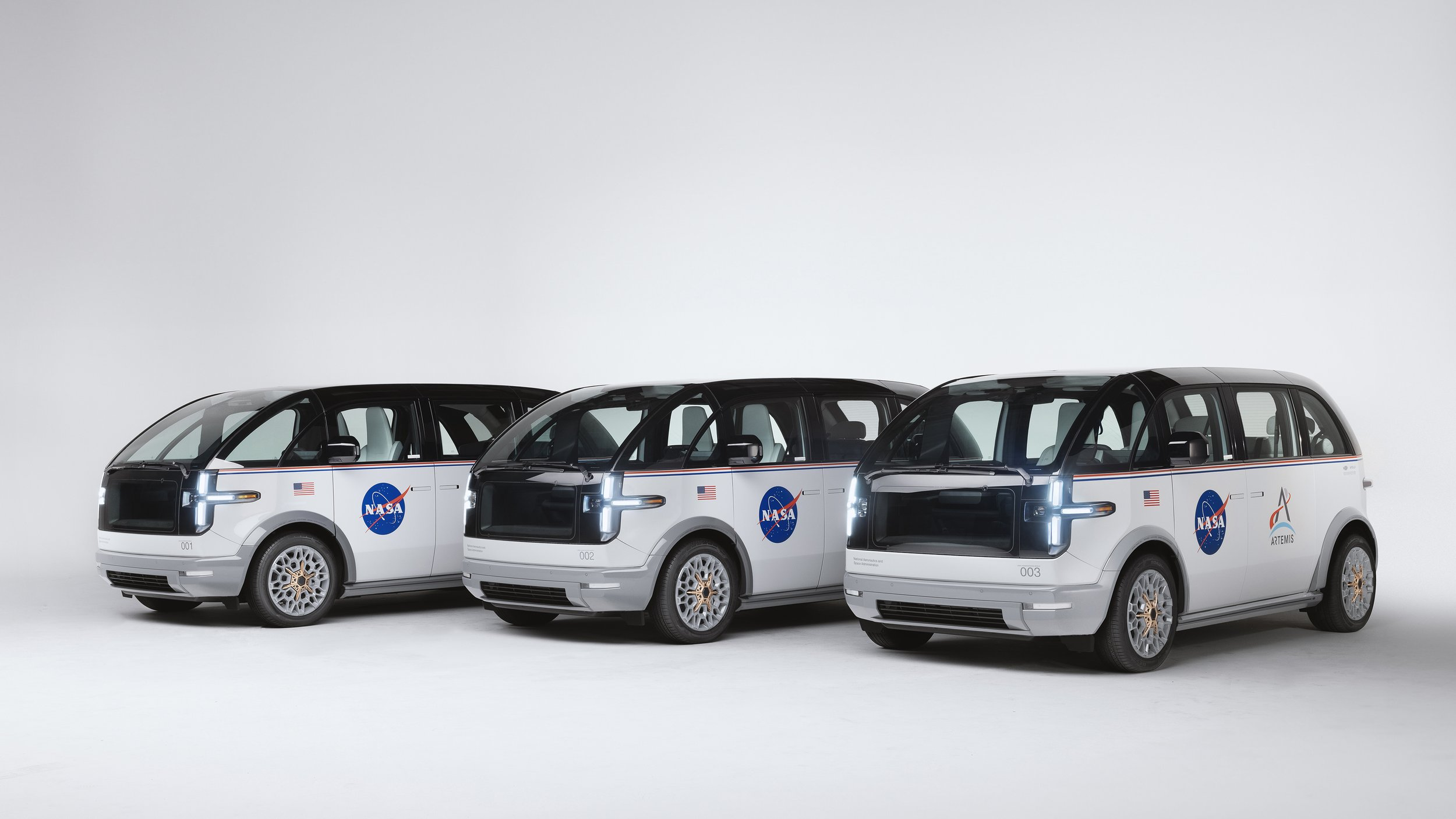 A photo of three NASA vans from Canoo. 