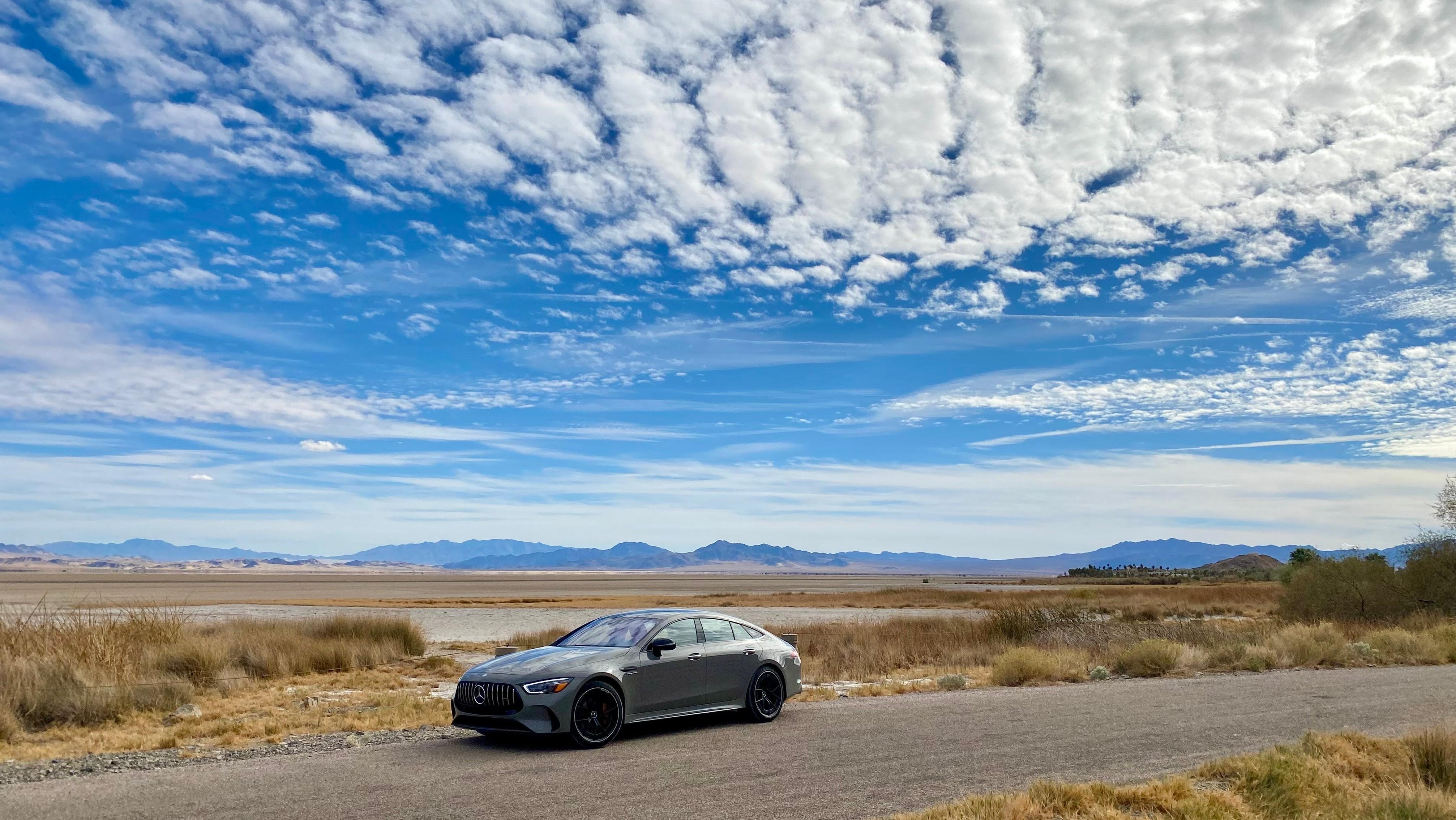 A photo of the gray AMG GT four door from the side in the desert