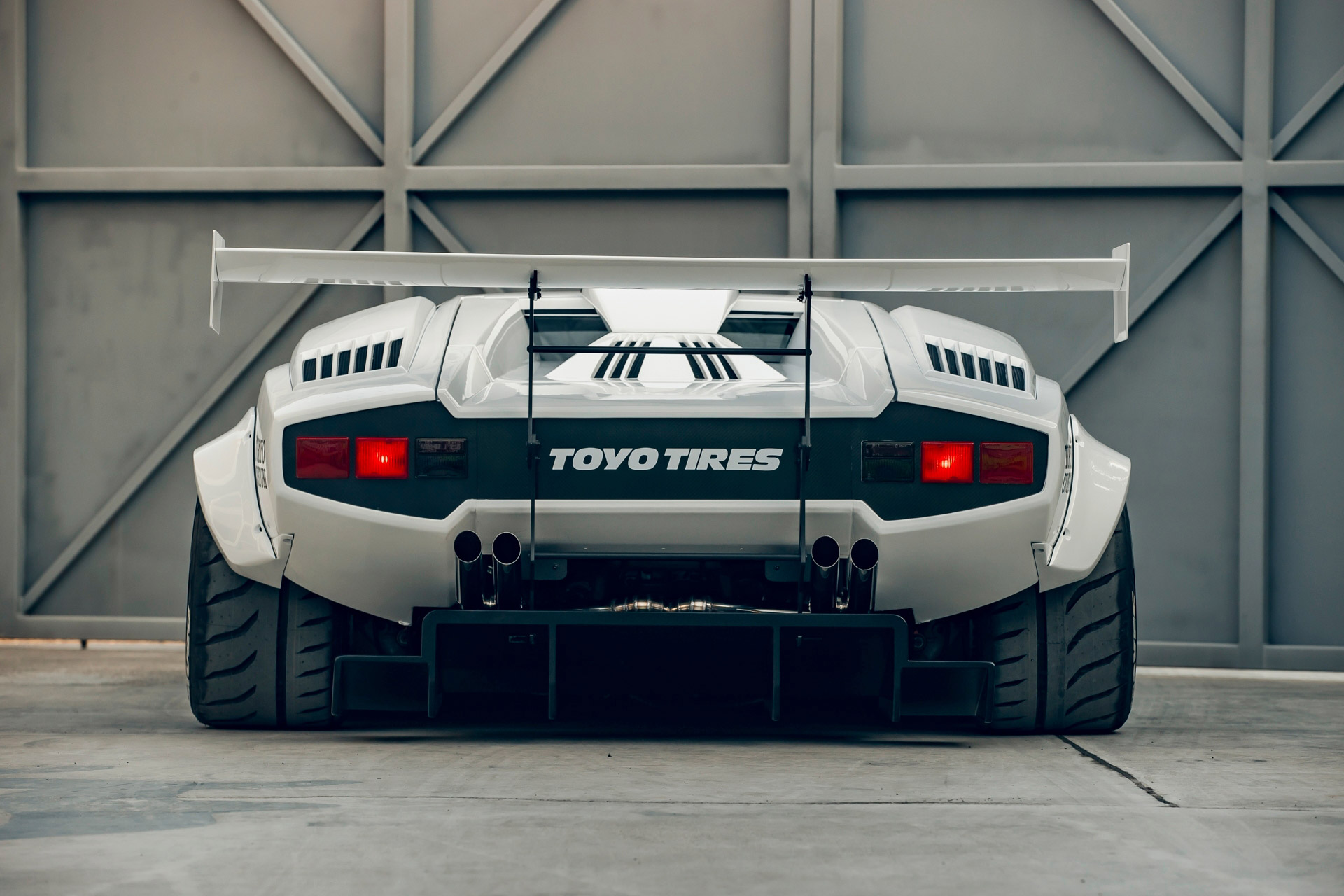 Rear view of a white Lamborghini Countach with a Liberty Walk body kit