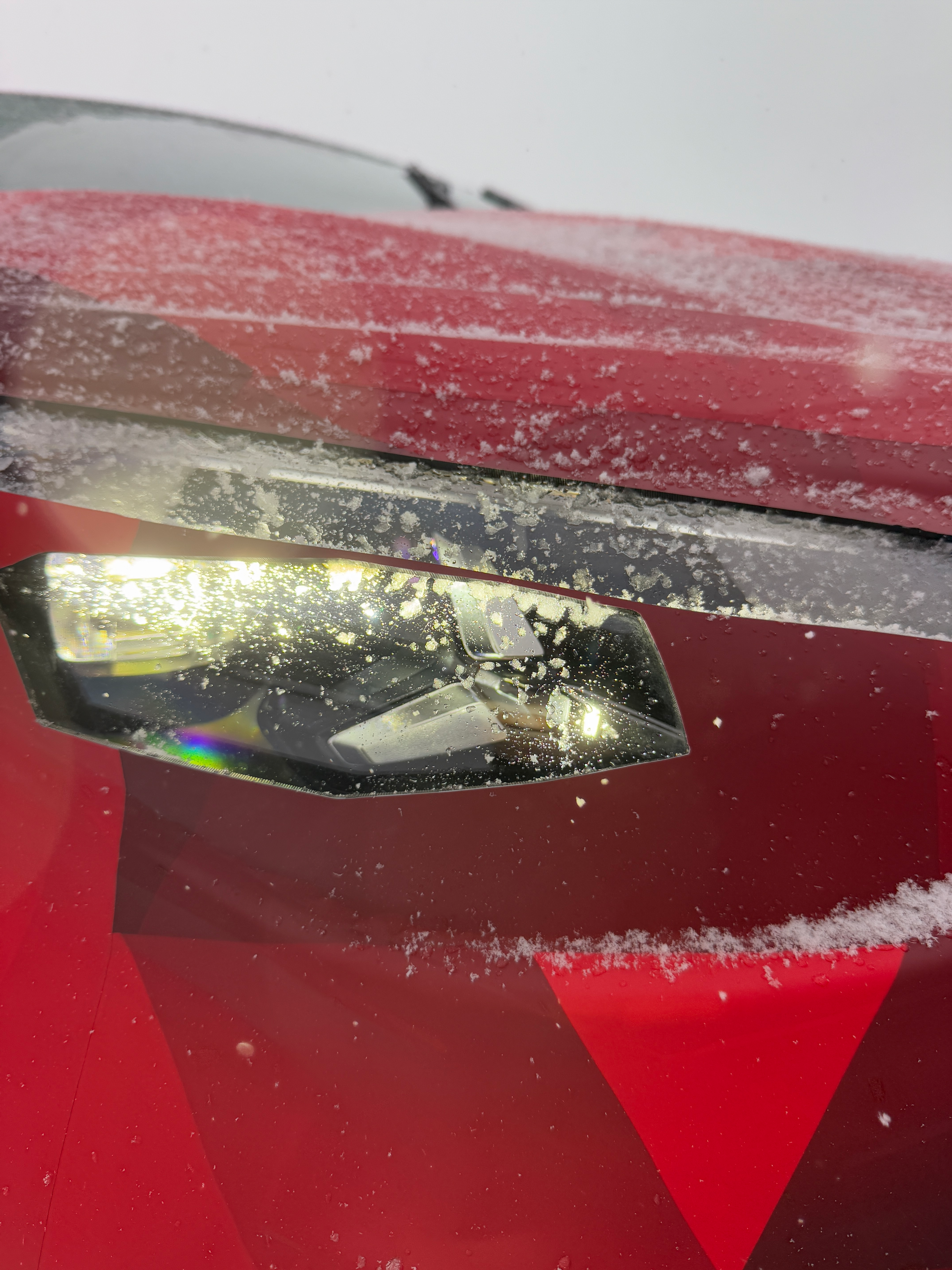 Headlight of a camouflaged Mercedes-Benz CLA EV prototype