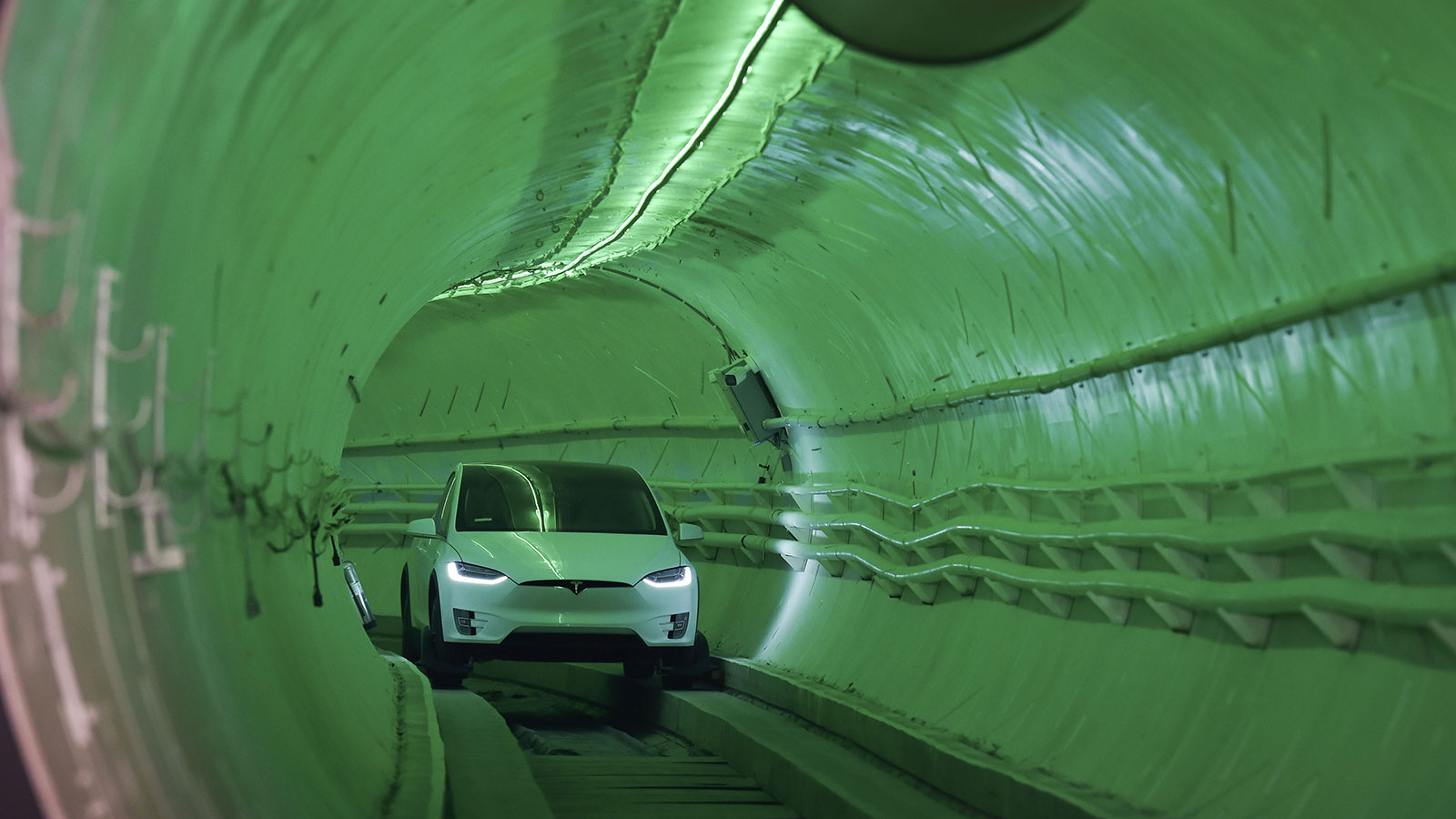 A photo of a Tesla driving through a Boring Company tunnel. 