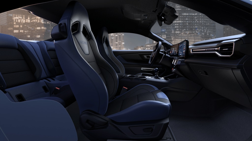 The interior of a 2024 Ford Mustang coupe, with blue accents, rendered against a city backdrop.