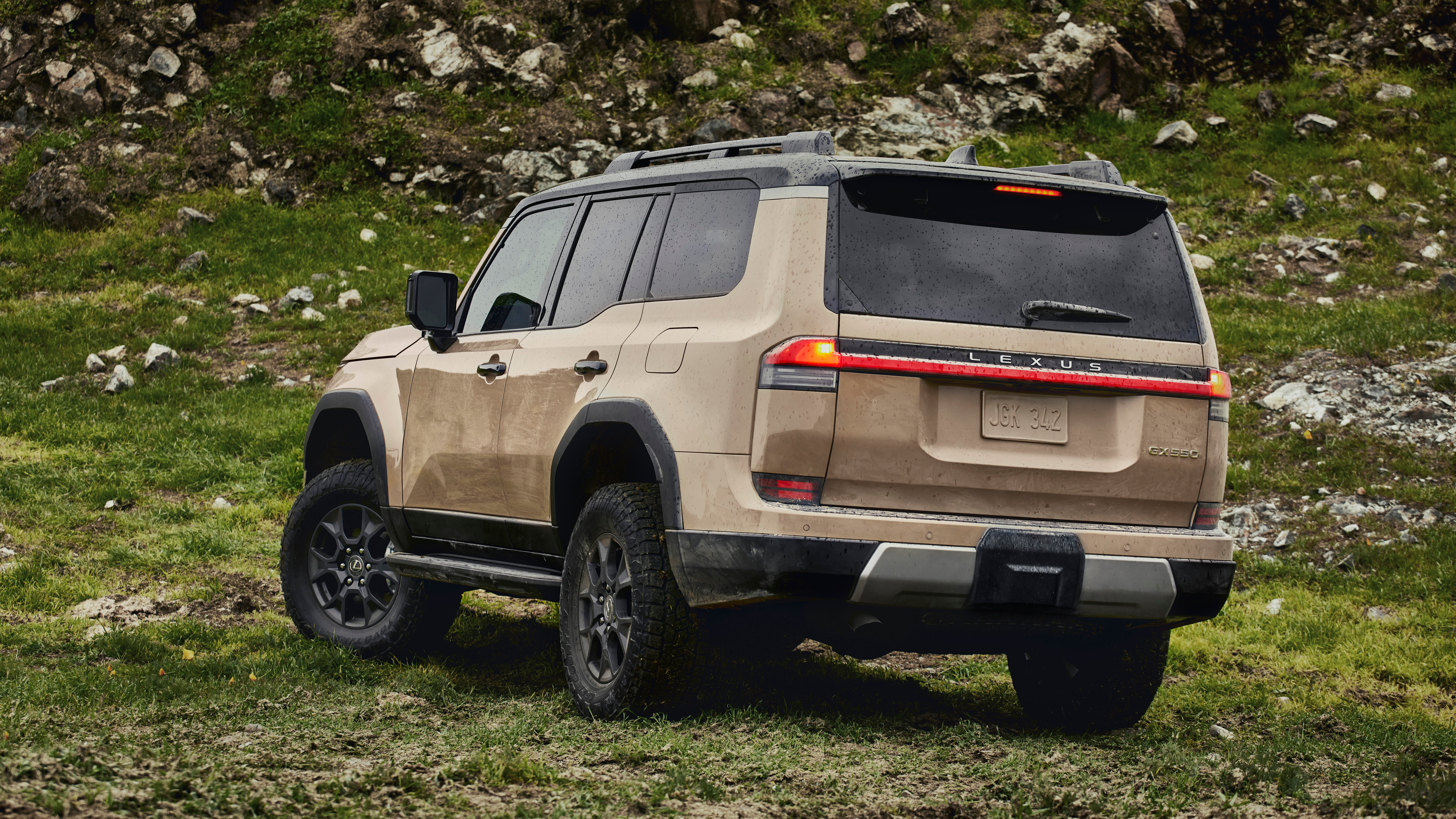 Rear 3/4 view of a brown Lexus GX on a mountain