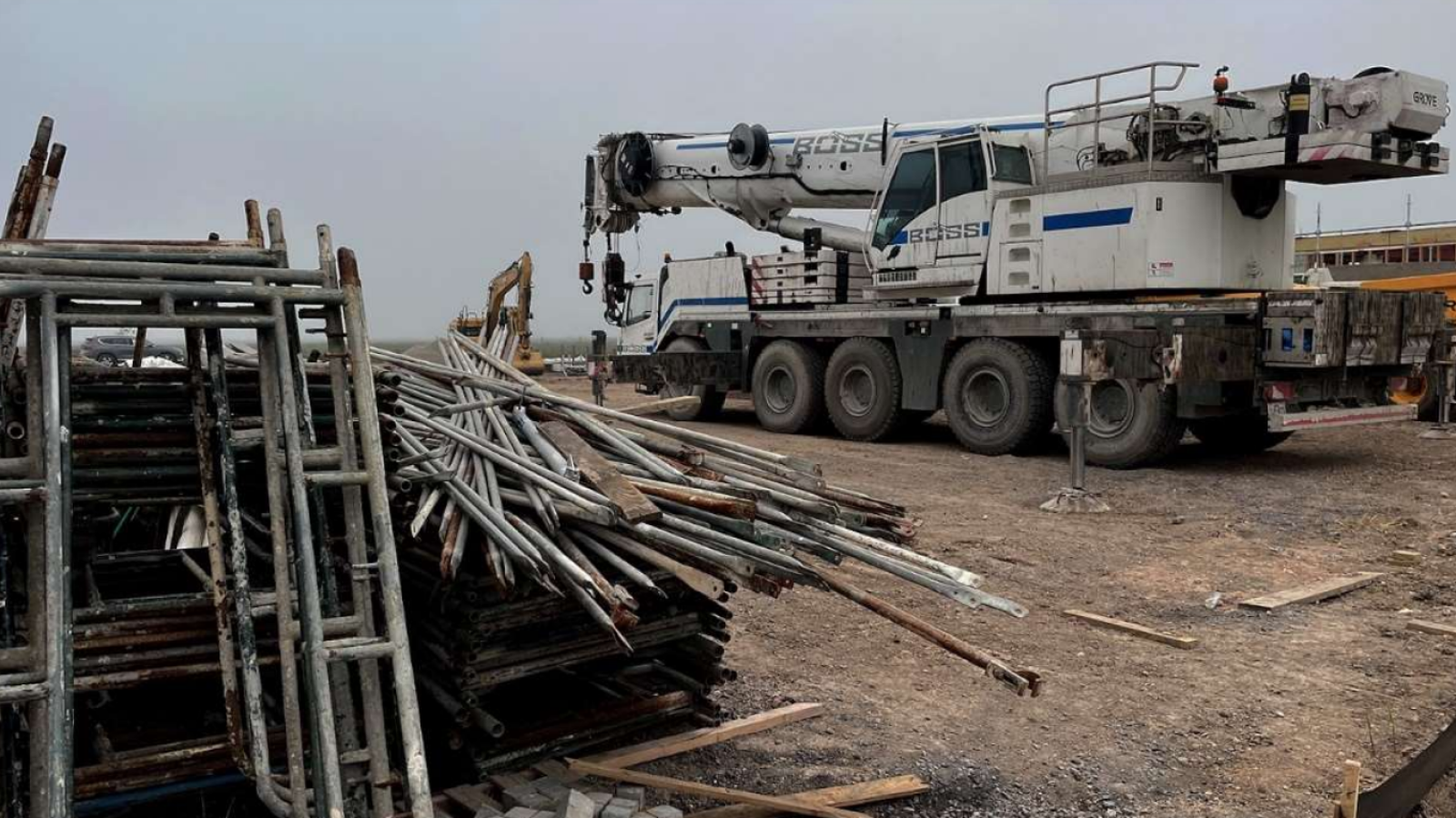 A photo of cranes and building materials on a plot of land. 