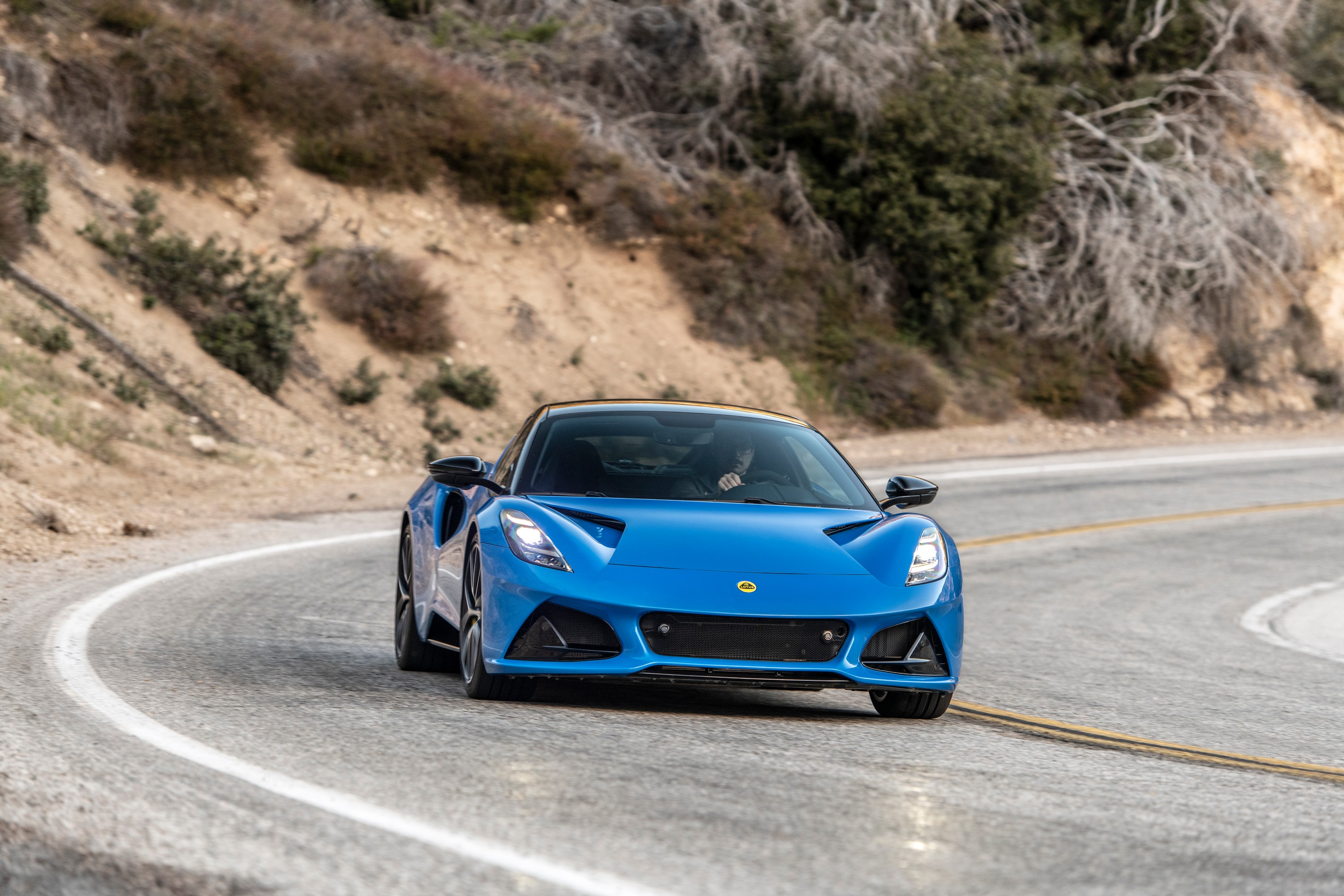 The front view of the 2023 Lotus Emira in Seneca Blue on a canyon road.