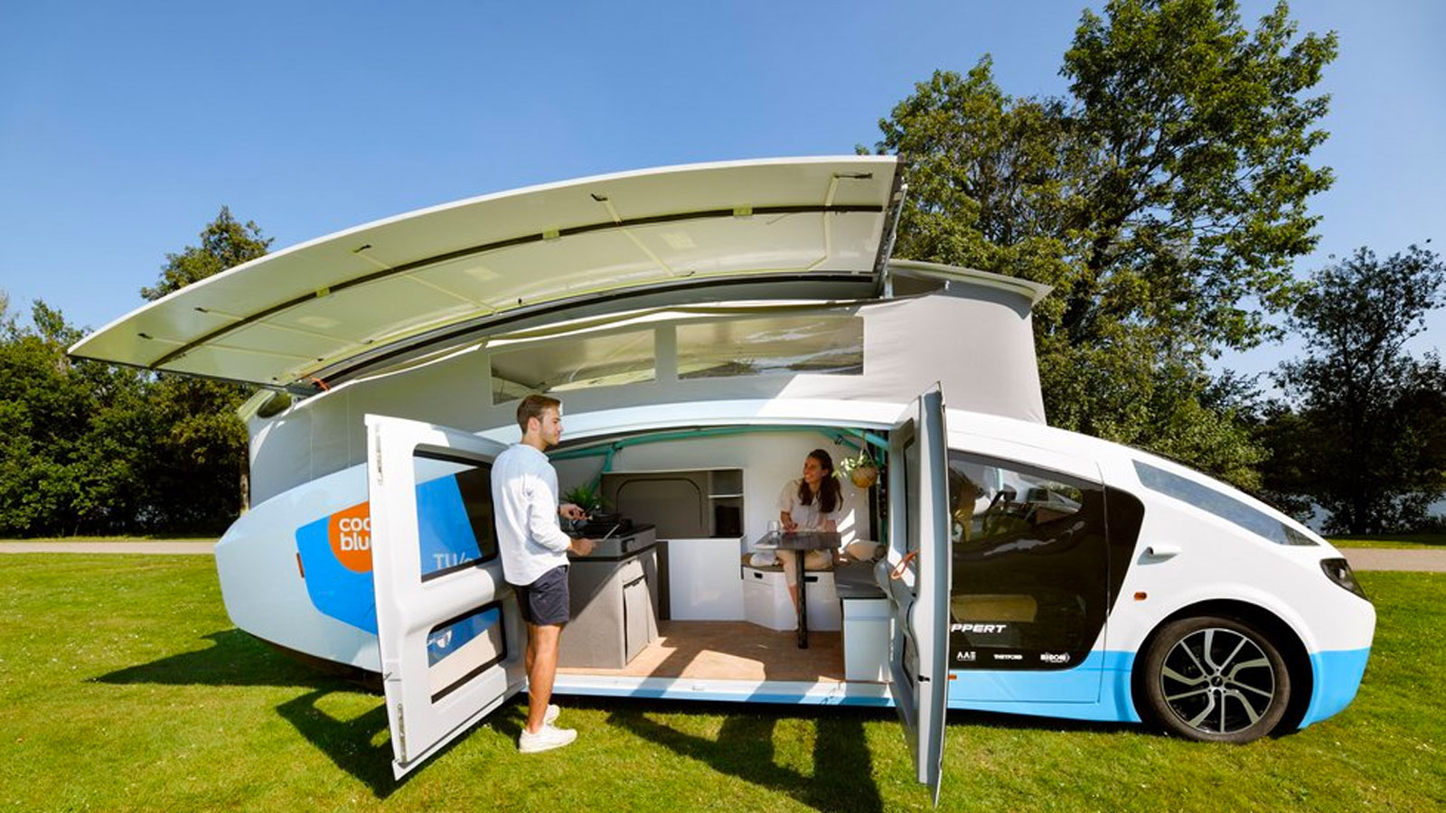 The electric campervan parked up with its roof popped open 