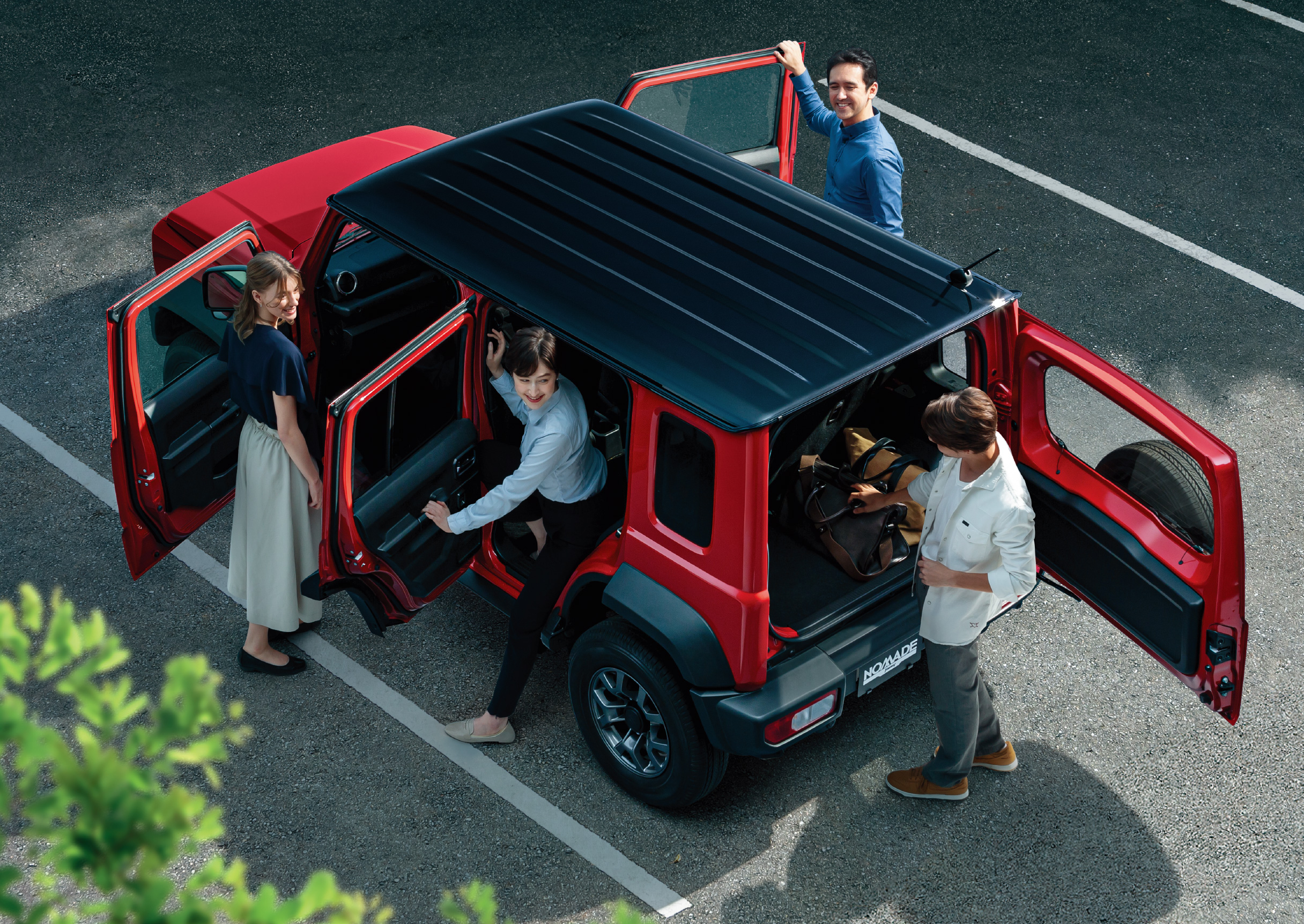 four people getting into a red jimny nomade 