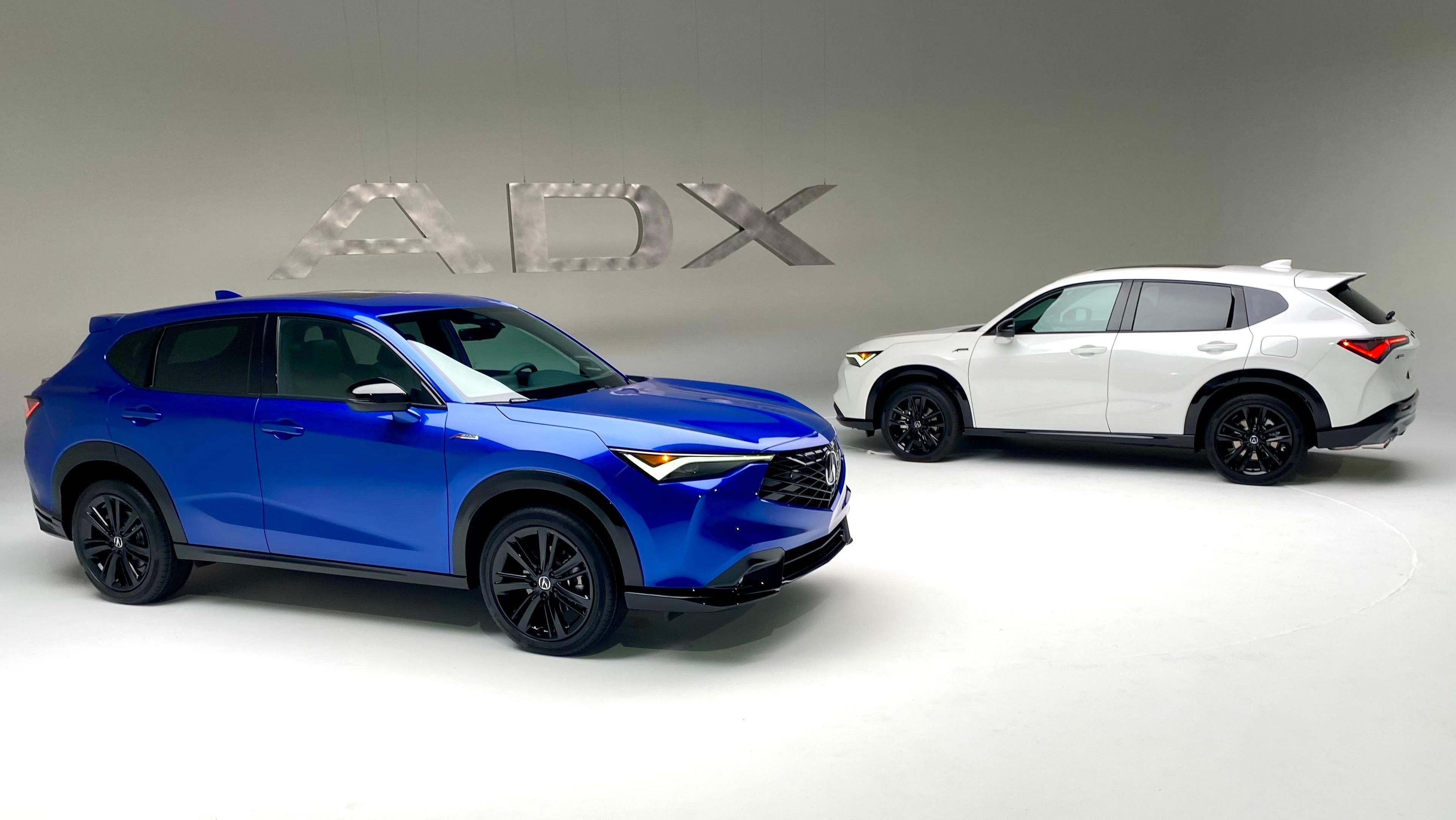 A photo of the Blue and White ADX parked in a white photo studio in front of a metal ADX sign