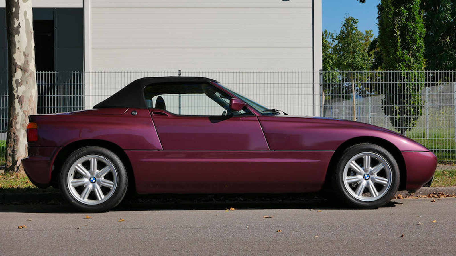 A BMW Z1 roadster in a dark burgundy color