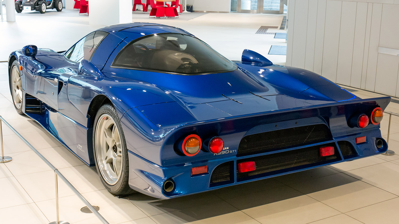 Image of the rear of the blue Nissan R390 GT1 road car as it appears in Nissan's Global Headquarters, dated 2015.