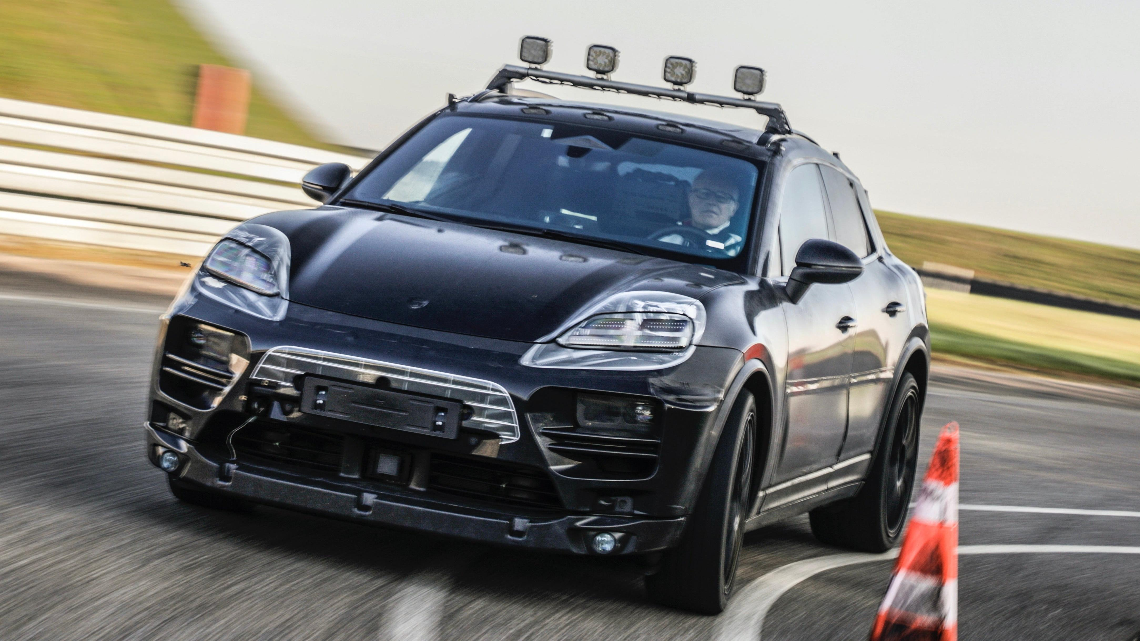 Front 3/4 view of a camouflaged Porsche Macan EV prototype