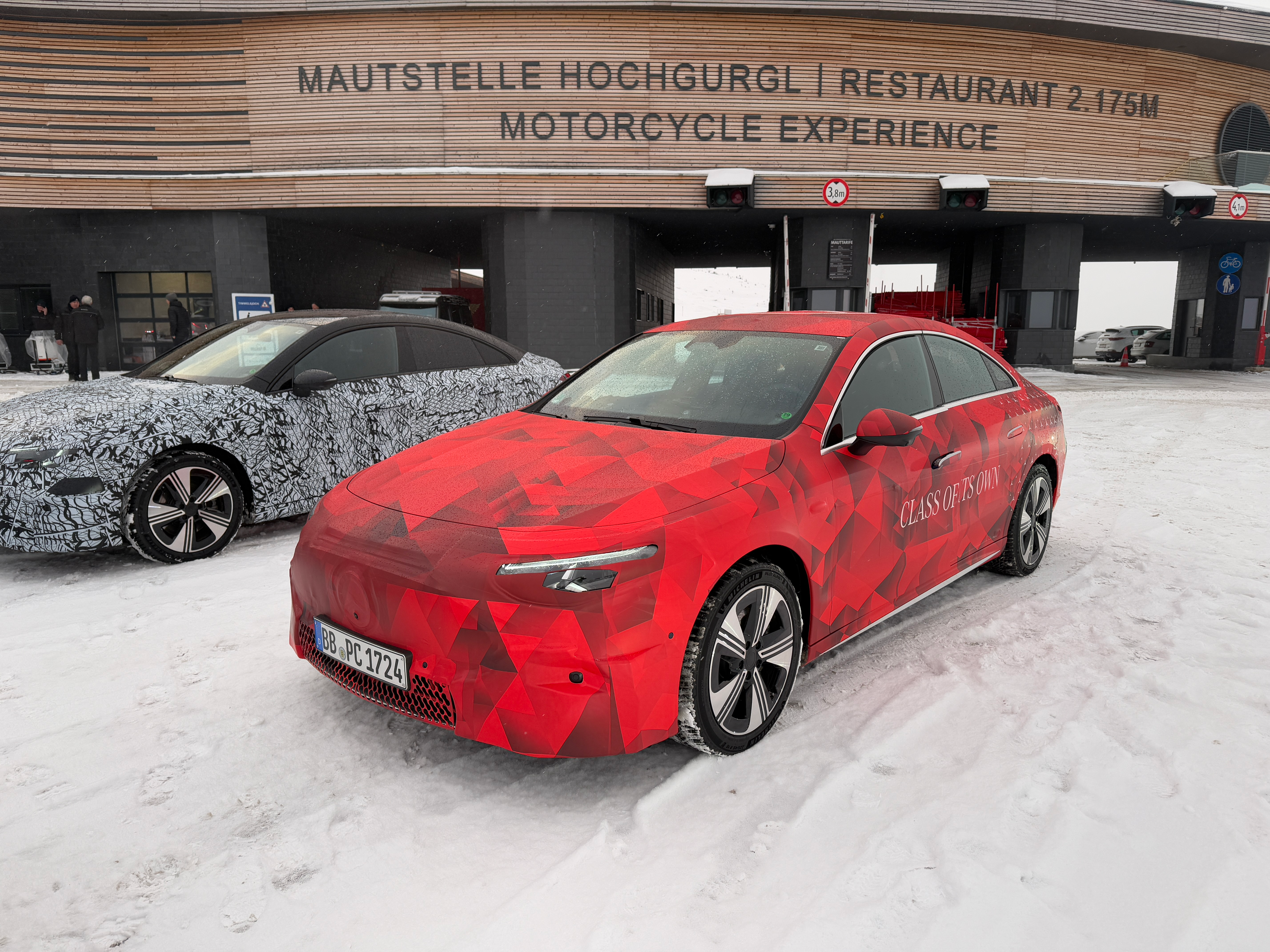 Front 3/4 view of a camouflaged Mercedes-Benz CLA EV prototype