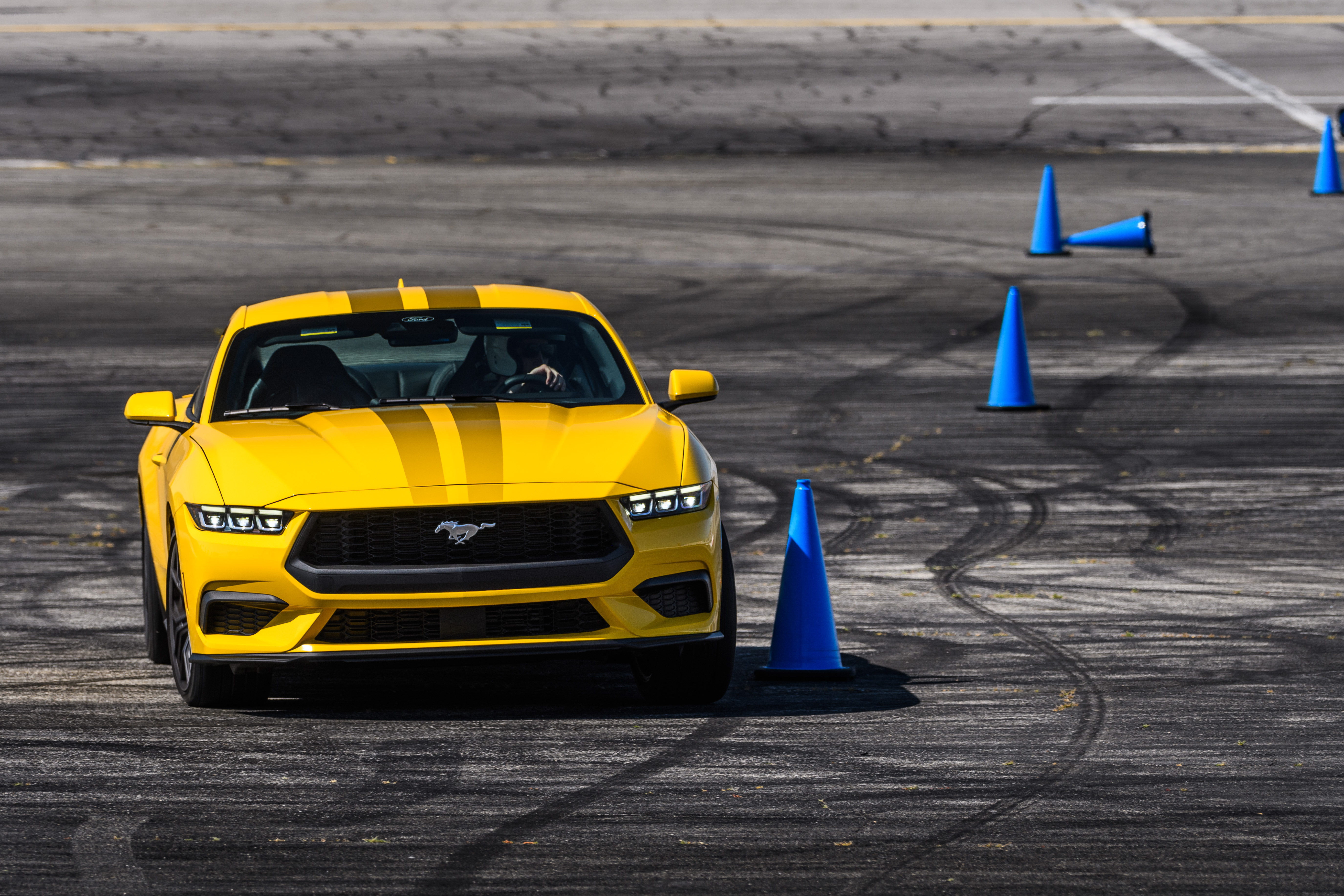 A yellow 2024 Ford Mustang EcoBoost on an autocross course at Irwindale Raceway in Irwindale, CA. 