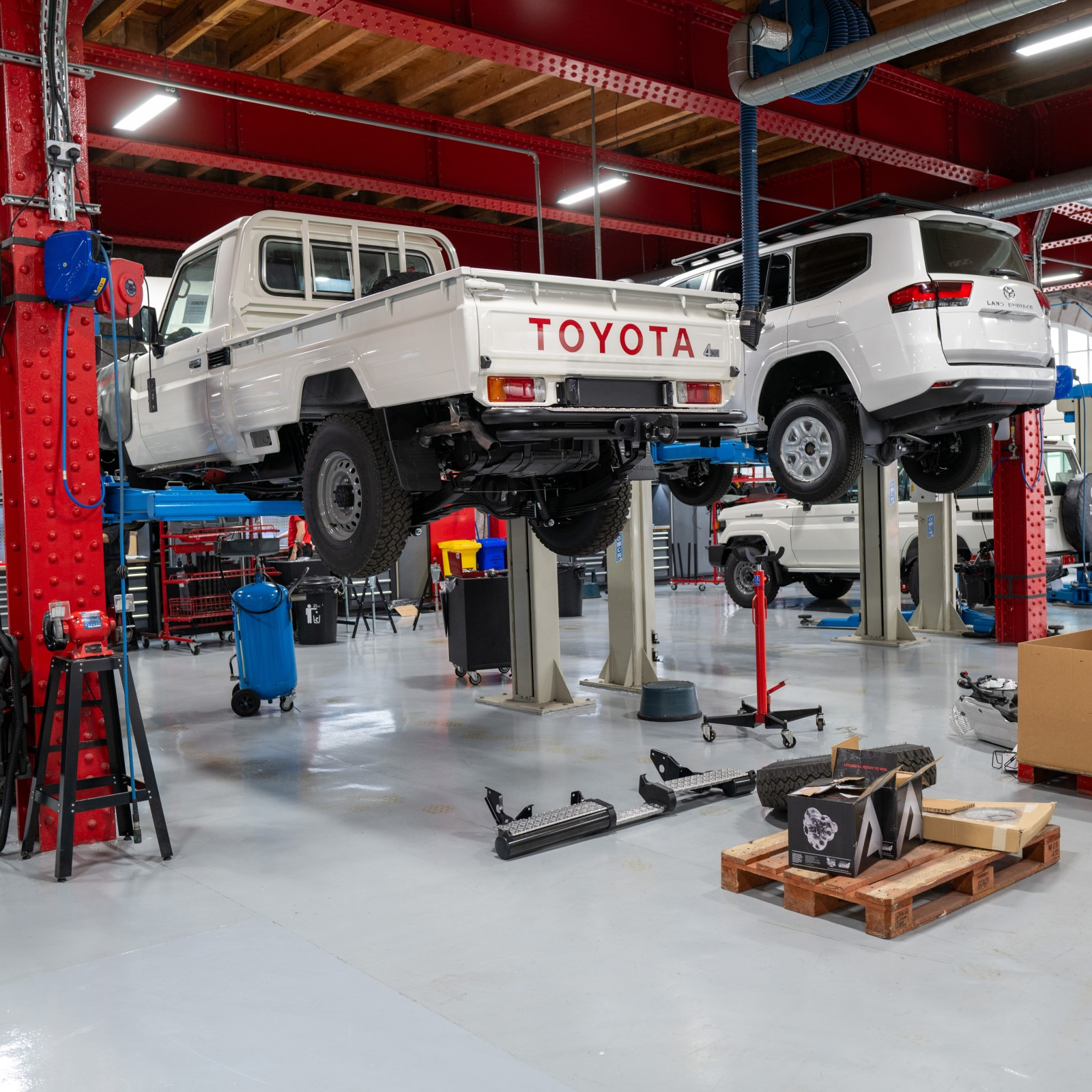 A photo of two Toyota trucks in a workshop. 