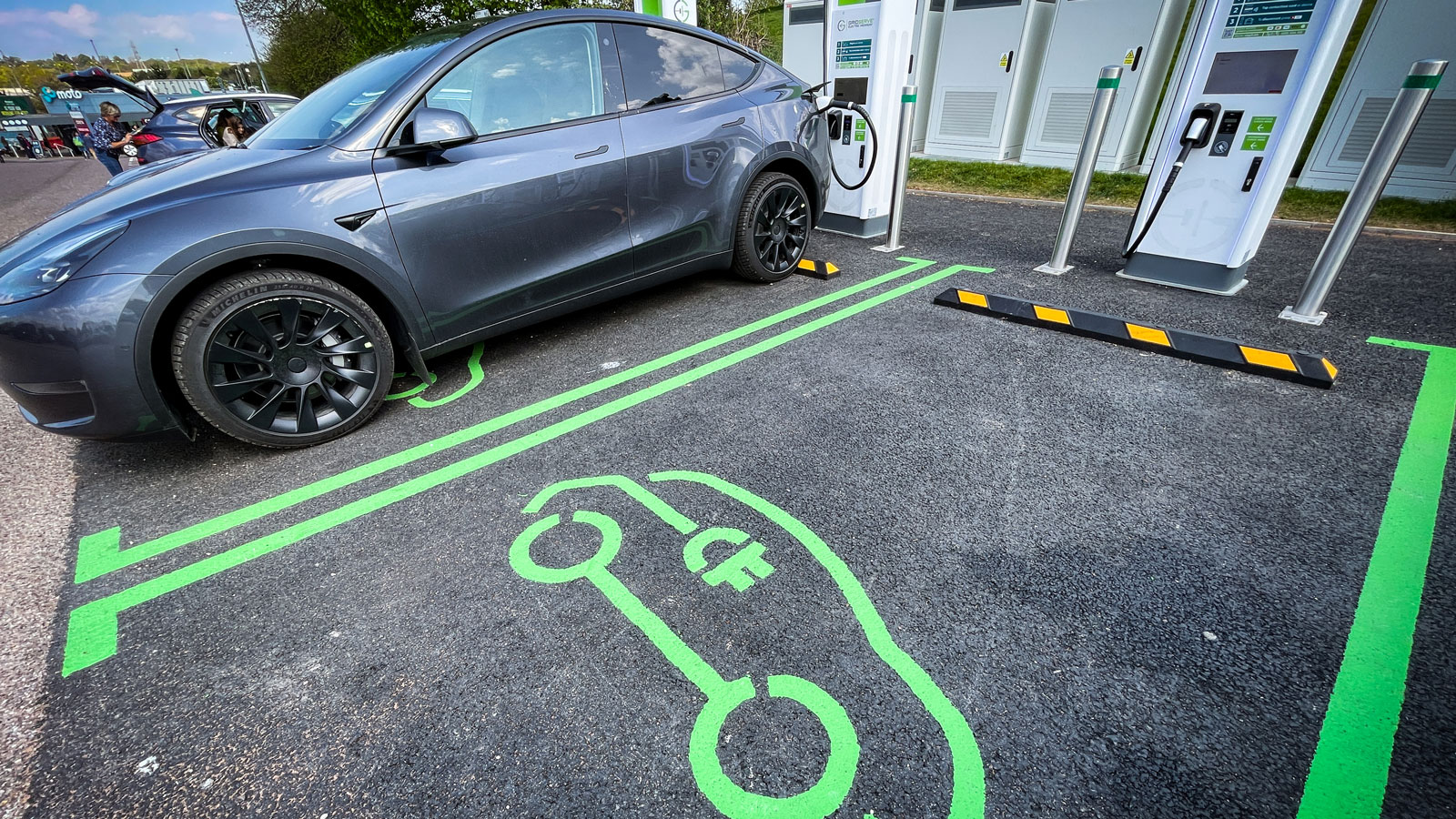 A photo of a Tesla charging at an EV station. 