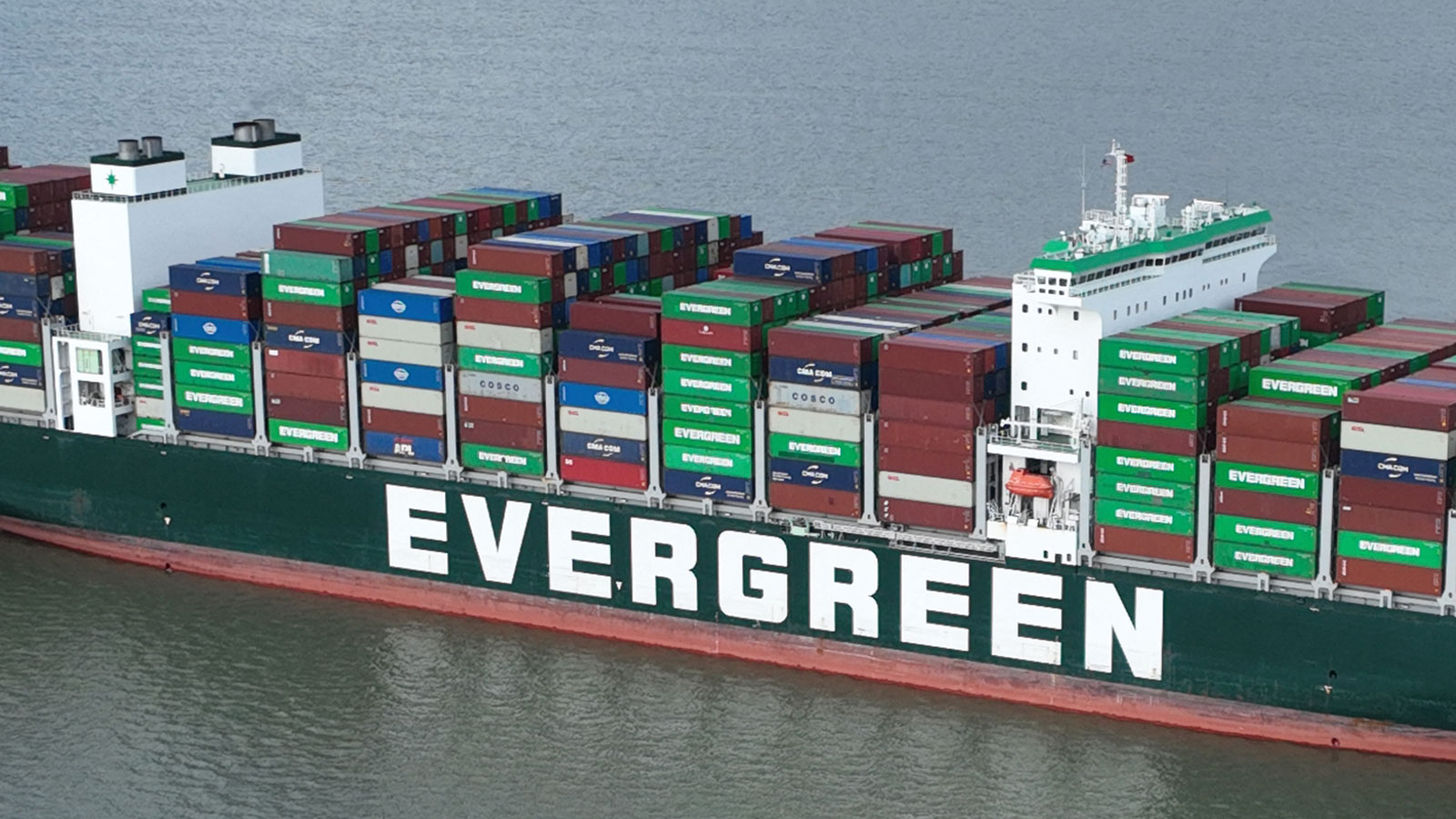 A close up photo of the Evergreen logo on the side of the stuck ship. 